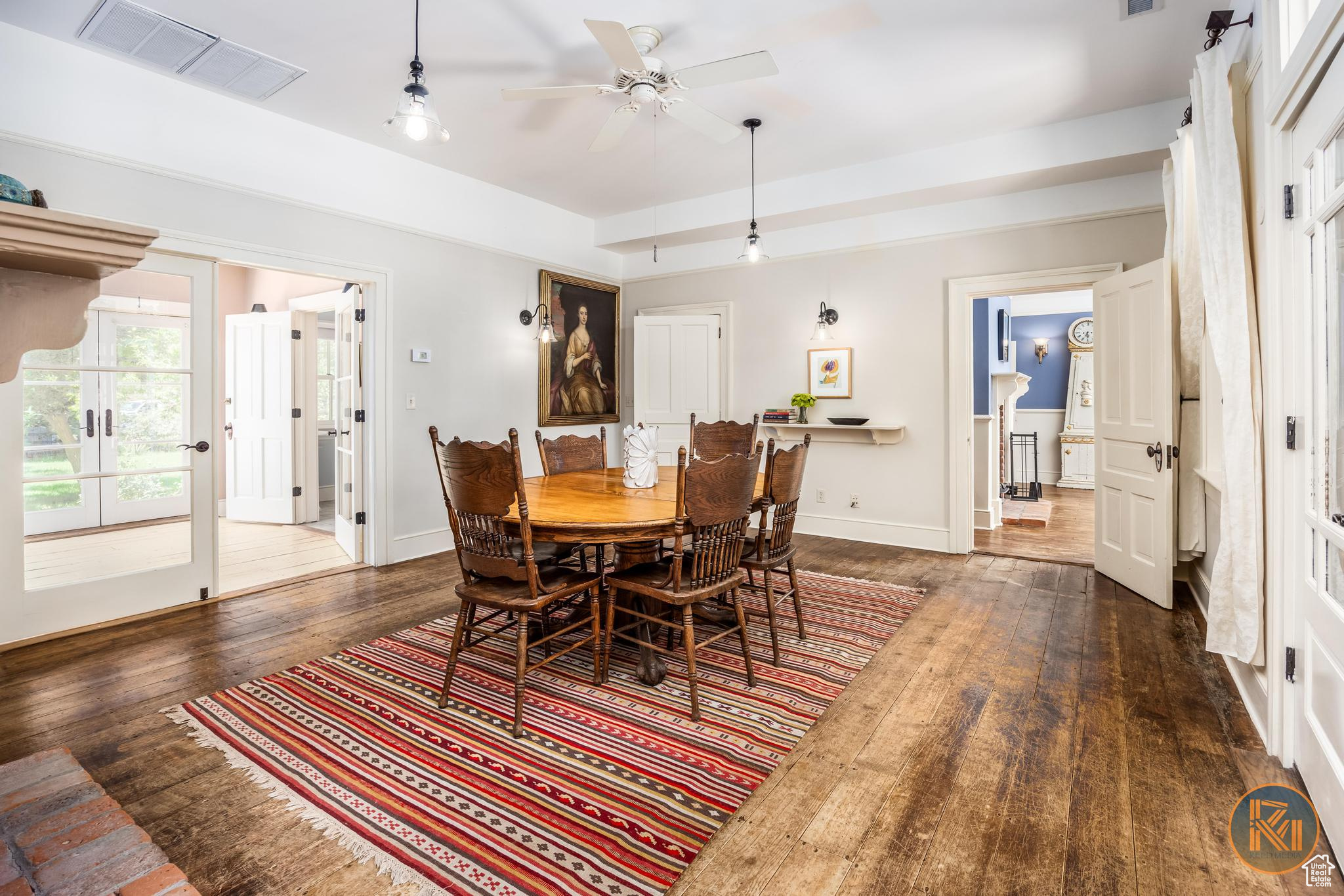 Dining room with ceiling fan, wood-type flooring, visible vents, and baseboards