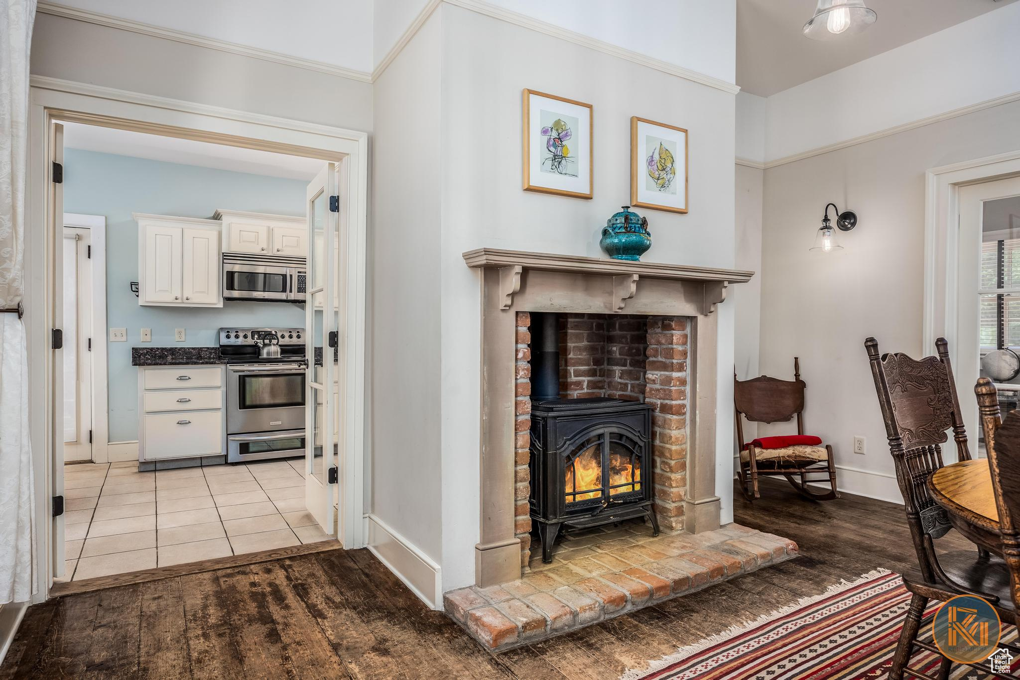 Interior space with light wood-type flooring, a wood stove, and baseboards