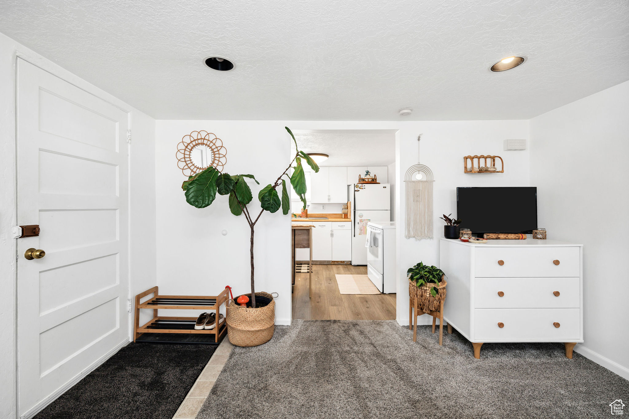 Interior space with light colored carpet and a textured ceiling