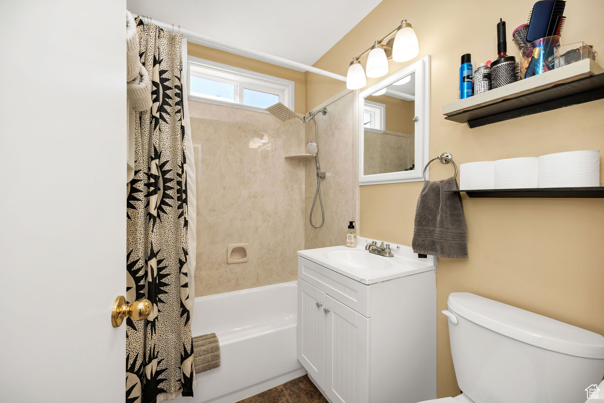 Bathroom with vanity, toilet, and shower / tub combo with curtain