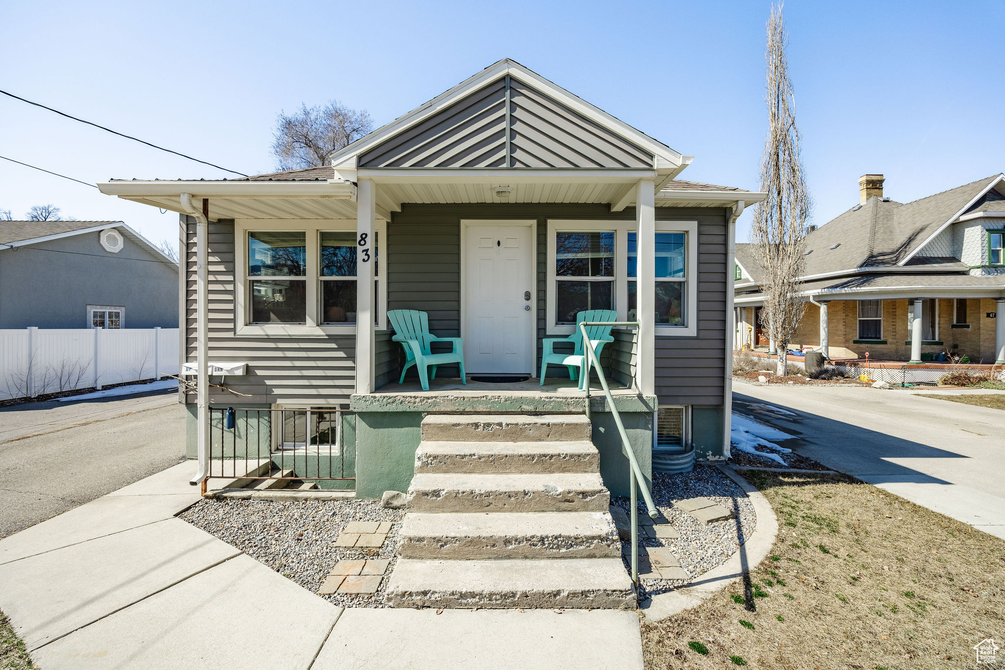 Bungalow with metal roof, covered porch, and fence