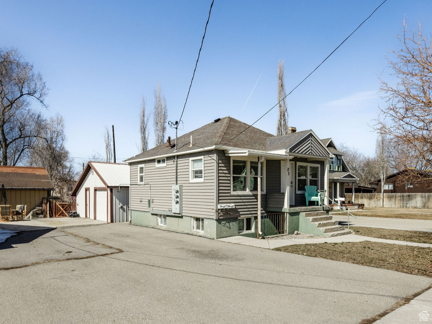 Bungalow featuring an outdoor structure, fence, a garage, and aphalt driveway