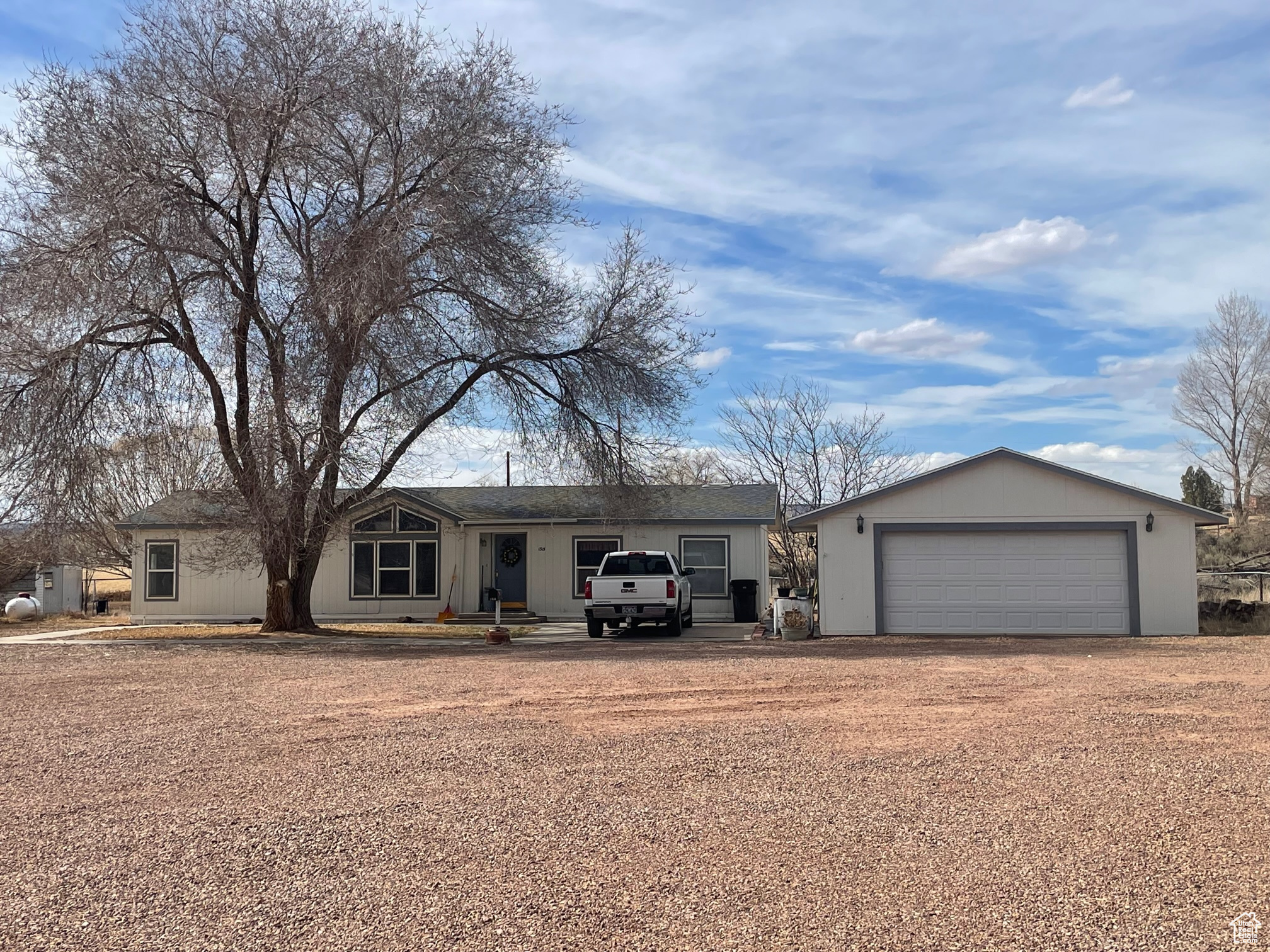 Ranch-style home featuring a detached garage and an outbuilding