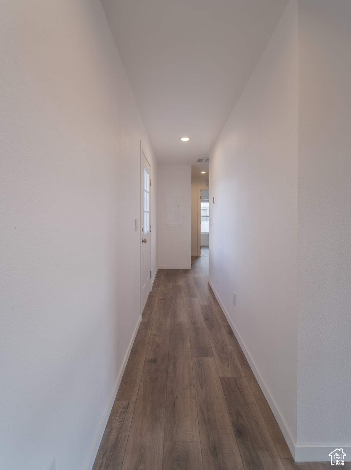 Hallway featuring recessed lighting, baseboards, and dark wood-style flooring