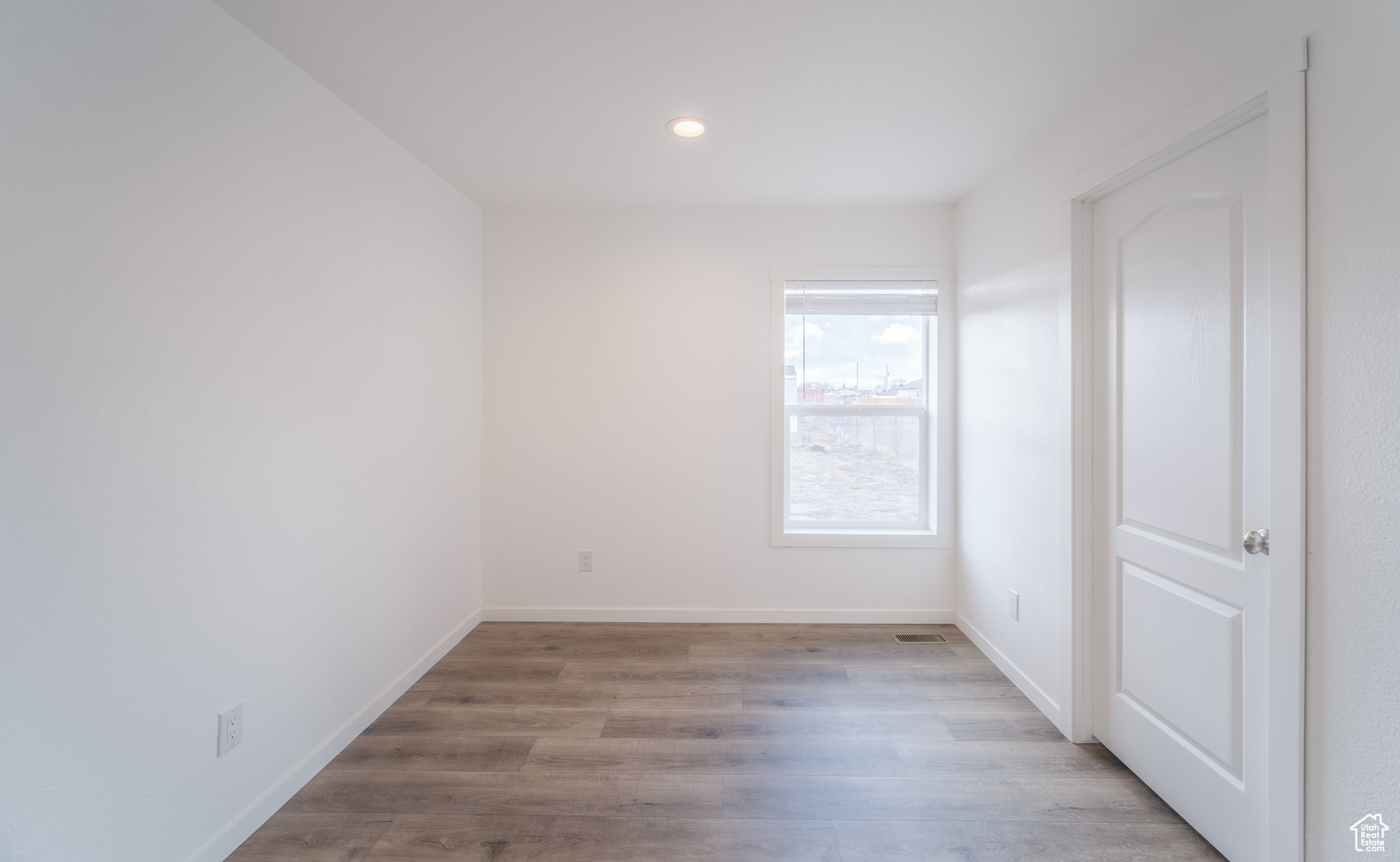 Empty room with recessed lighting, baseboards, and wood finished floors