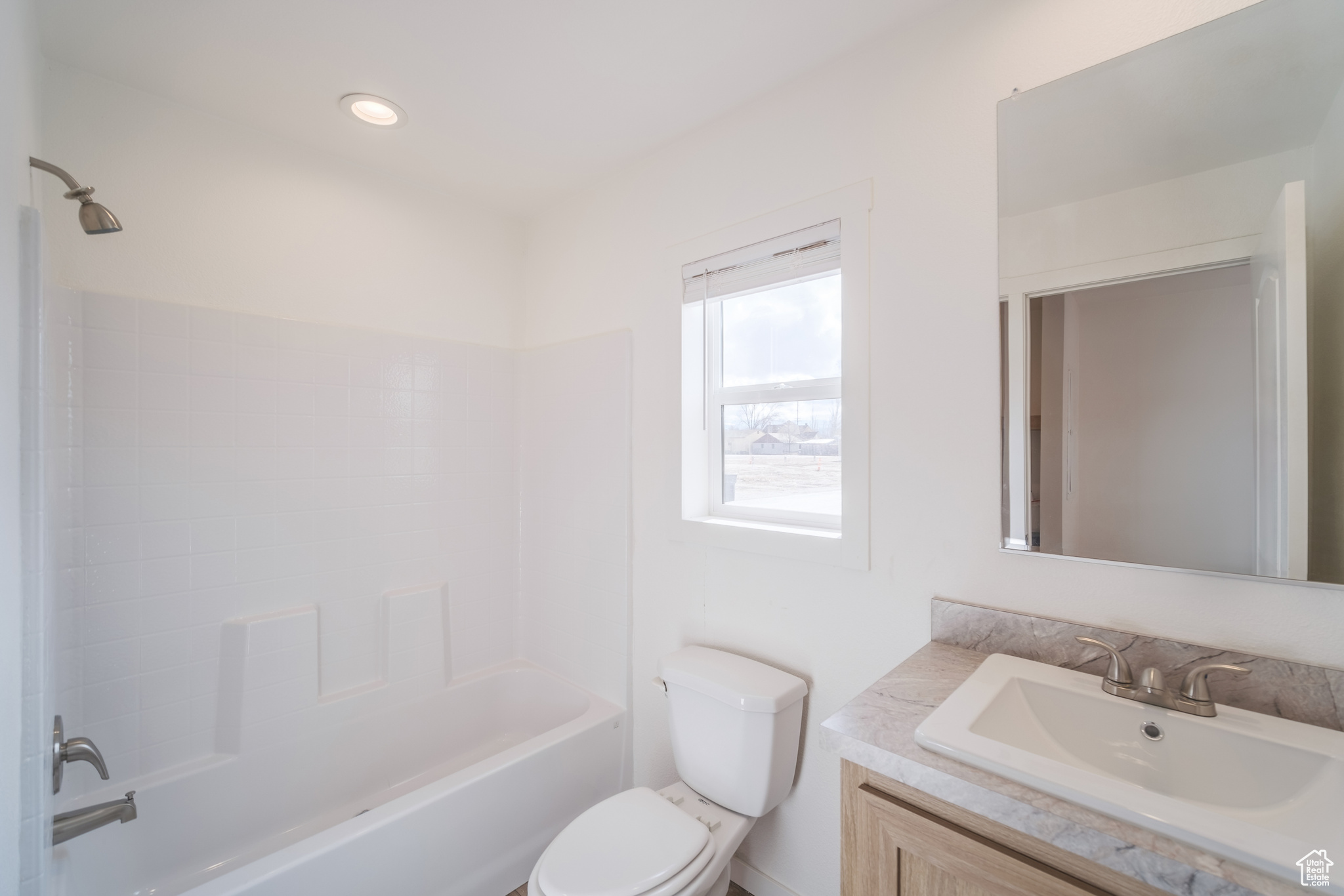 Bathroom featuring vanity, toilet, tub / shower combination, and recessed lighting