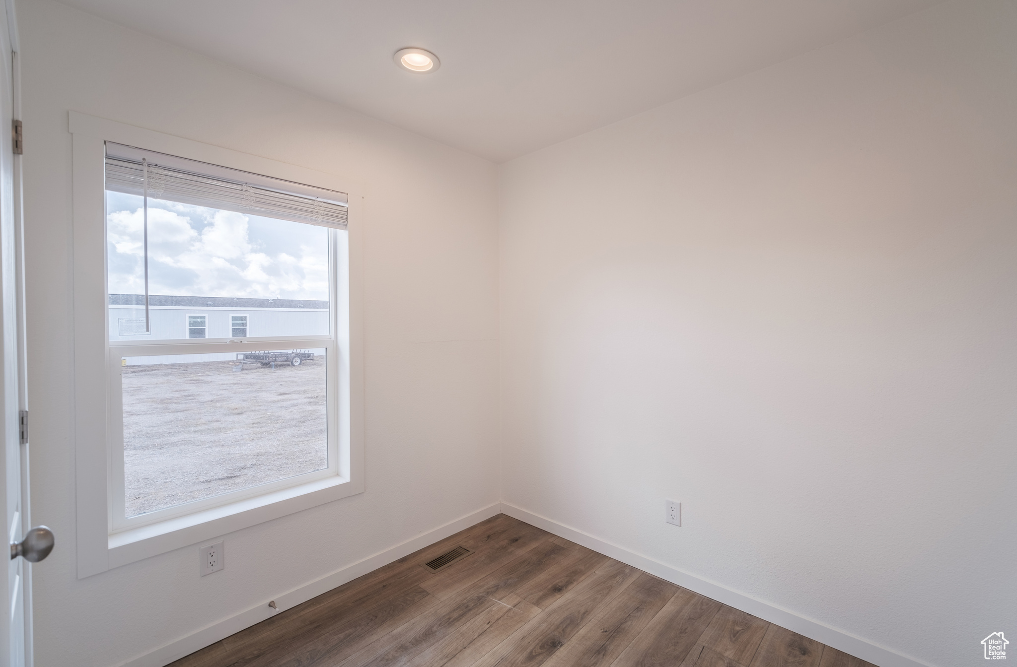 Empty room featuring recessed lighting, visible vents, baseboards, and wood finished floors
