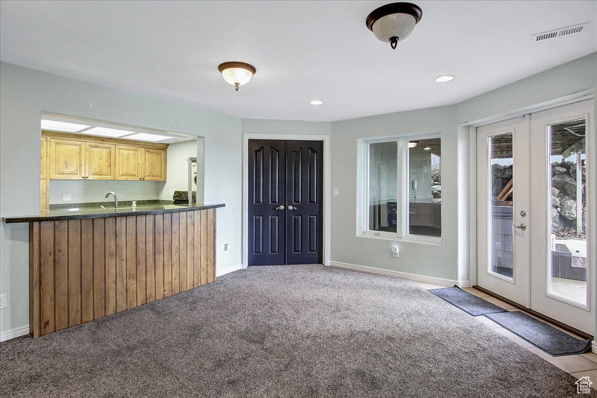 Kitchen featuring visible vents, dark countertops, french doors, carpet floors, and baseboards