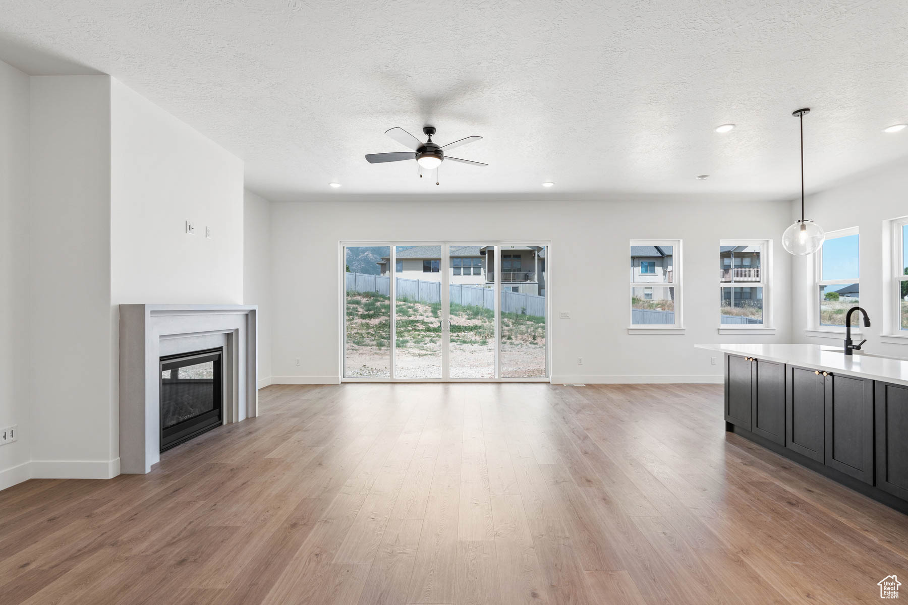Unfurnished living room featuring light wood-style flooring, a fireplace, and a wealth of natural light