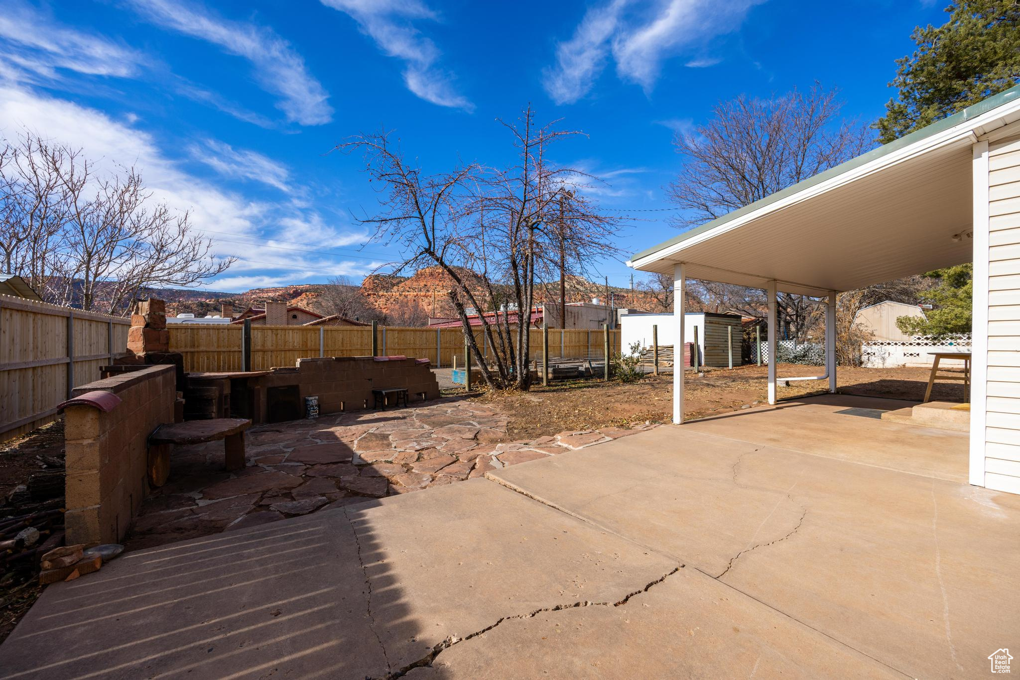 View of patio with a mountain view, an outdoor structure, and a fenced backyard