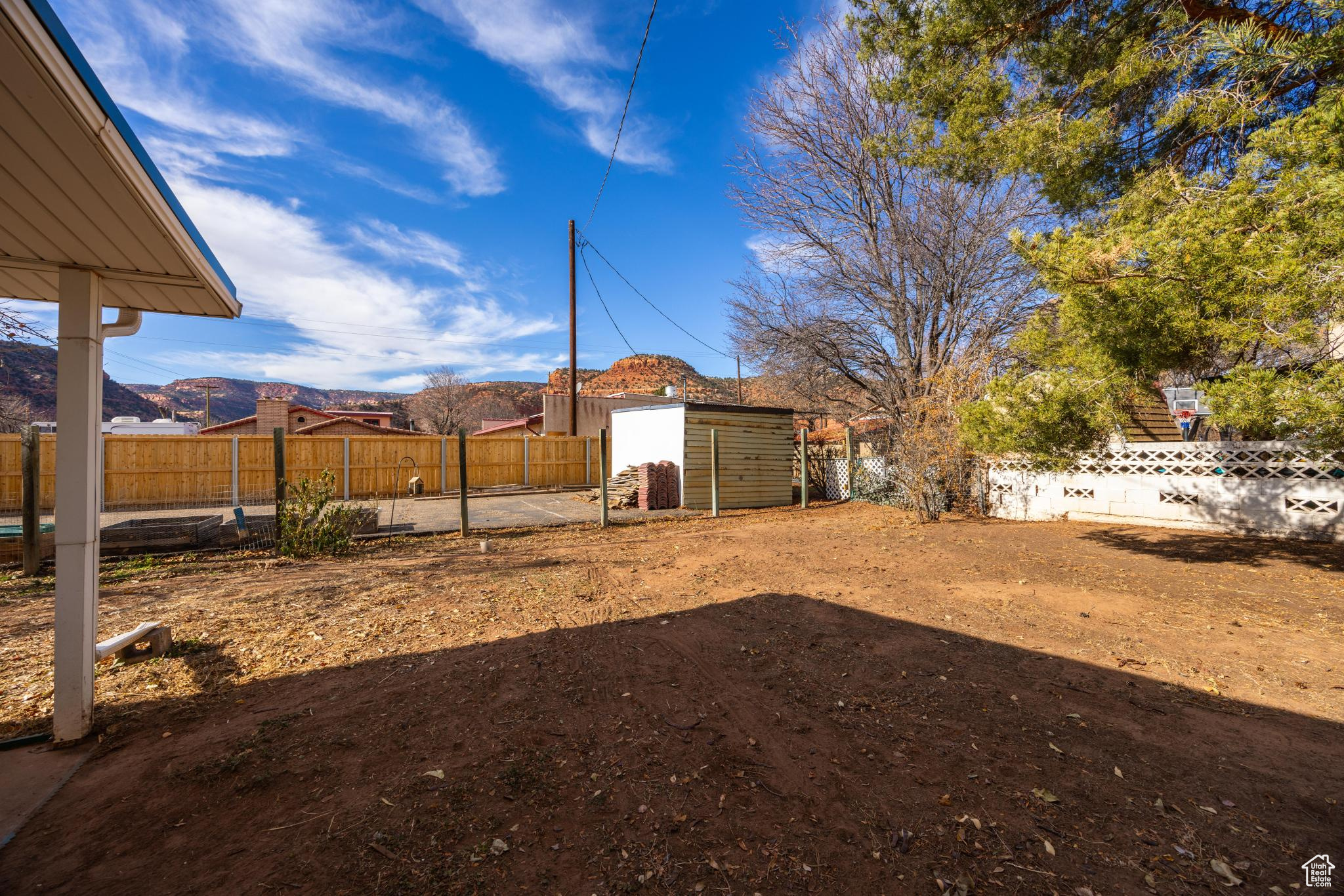 View of yard featuring a fenced backyard, a storage shed, an outdoor structure, and a mountain view