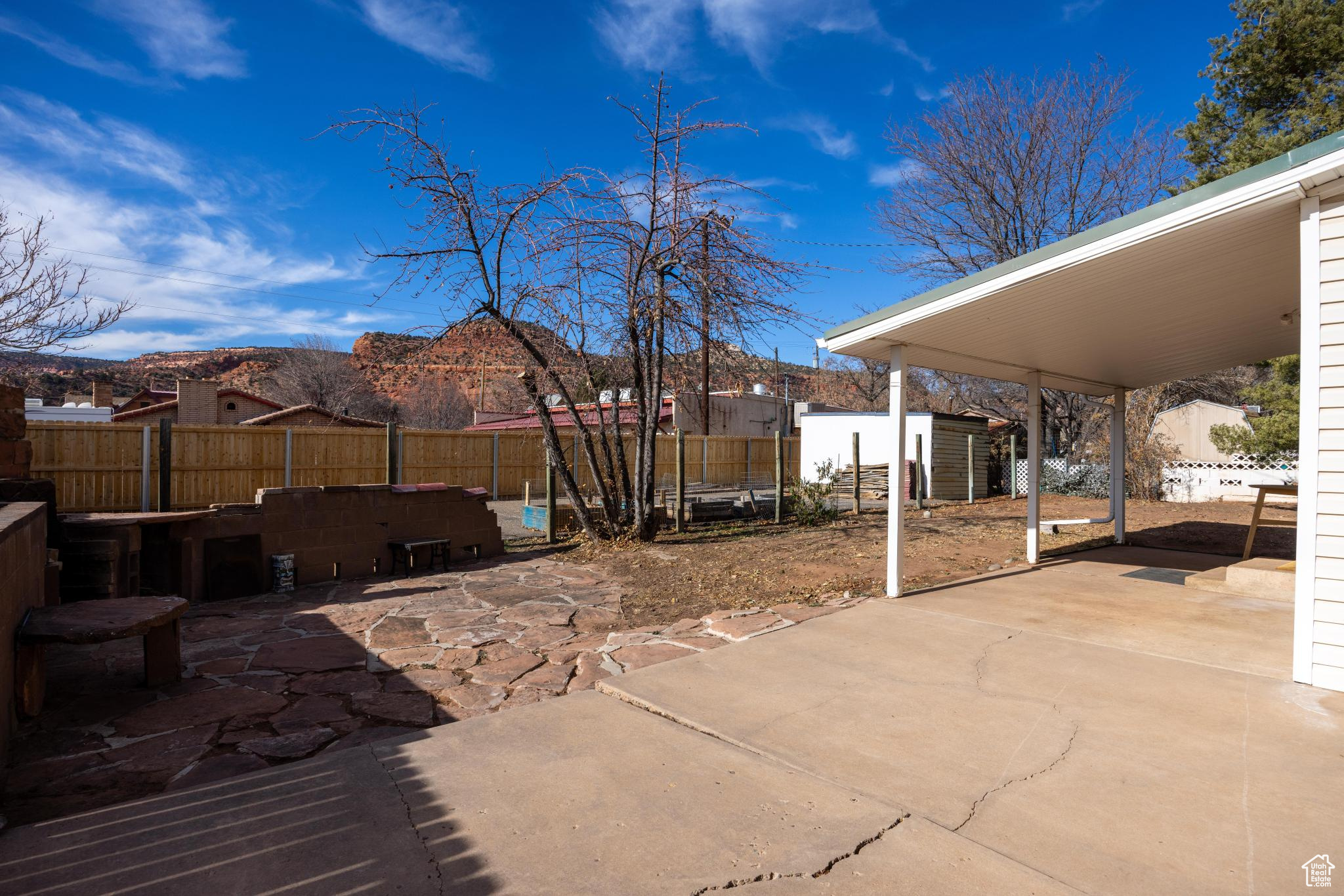 View of patio featuring an outdoor structure, a fenced backyard, and a mountain view