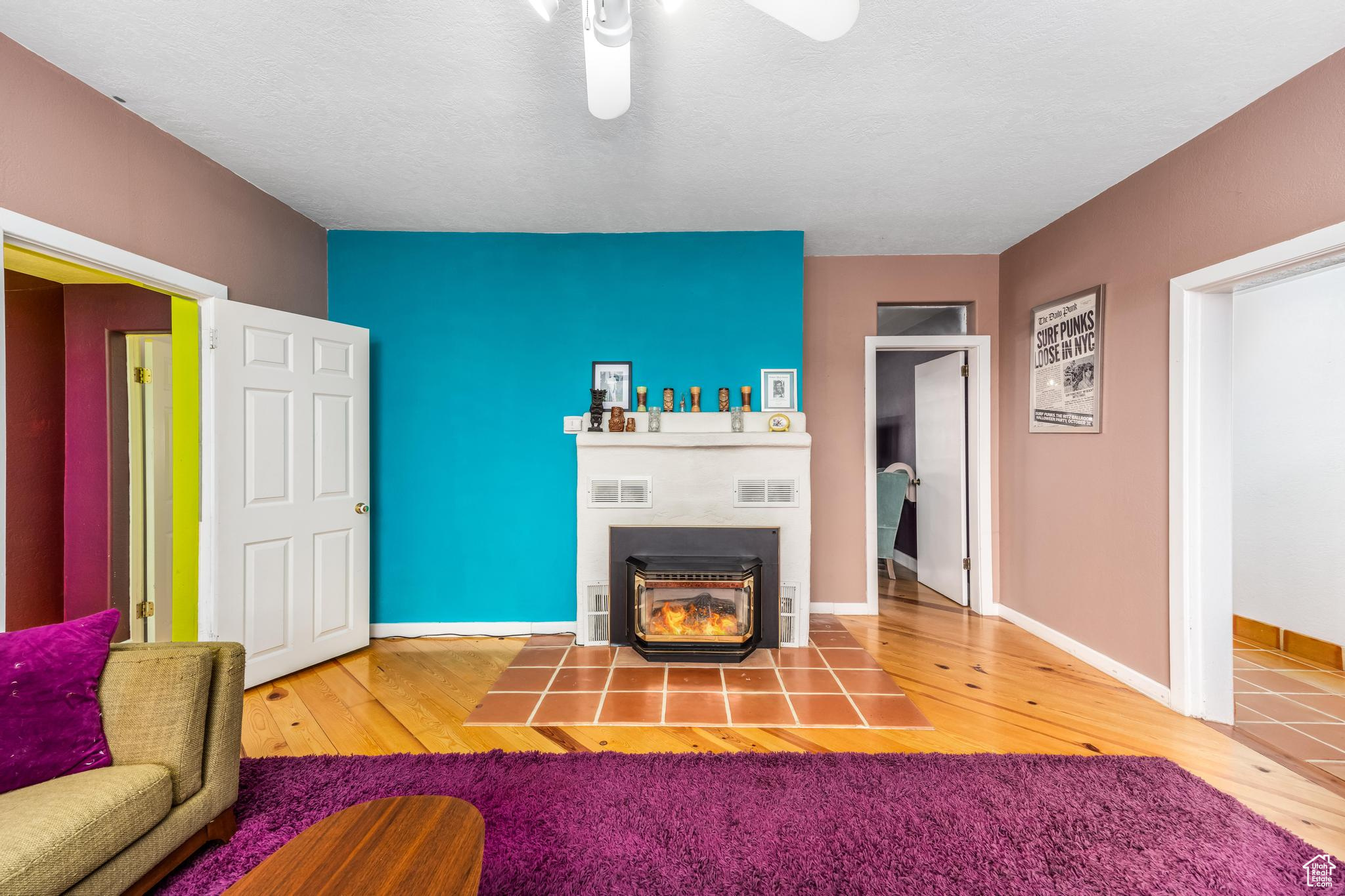 Unfurnished living room featuring hardwood / wood-style floors, baseboards, visible vents, and a fireplace