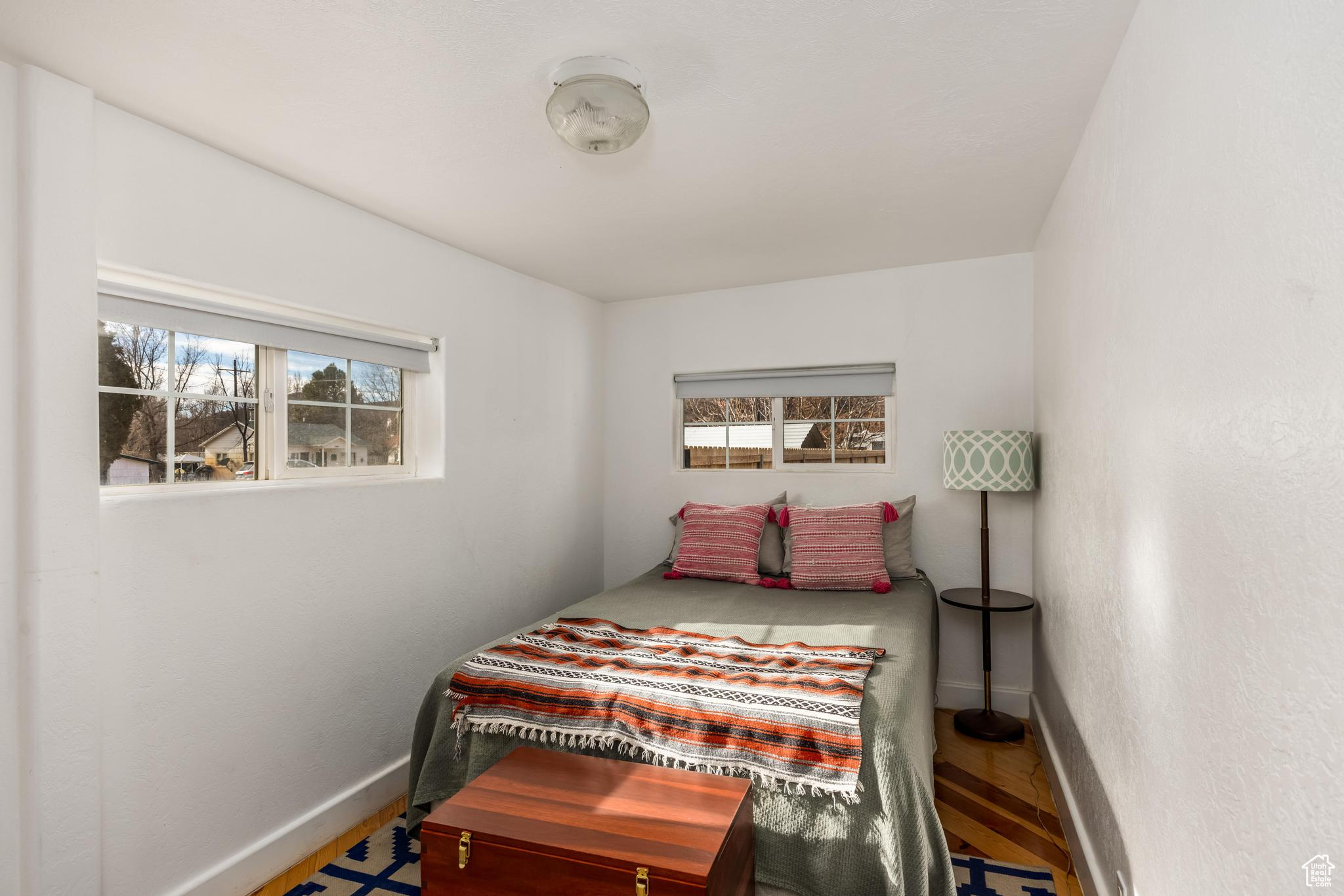 Bedroom with wood finished floors and baseboards