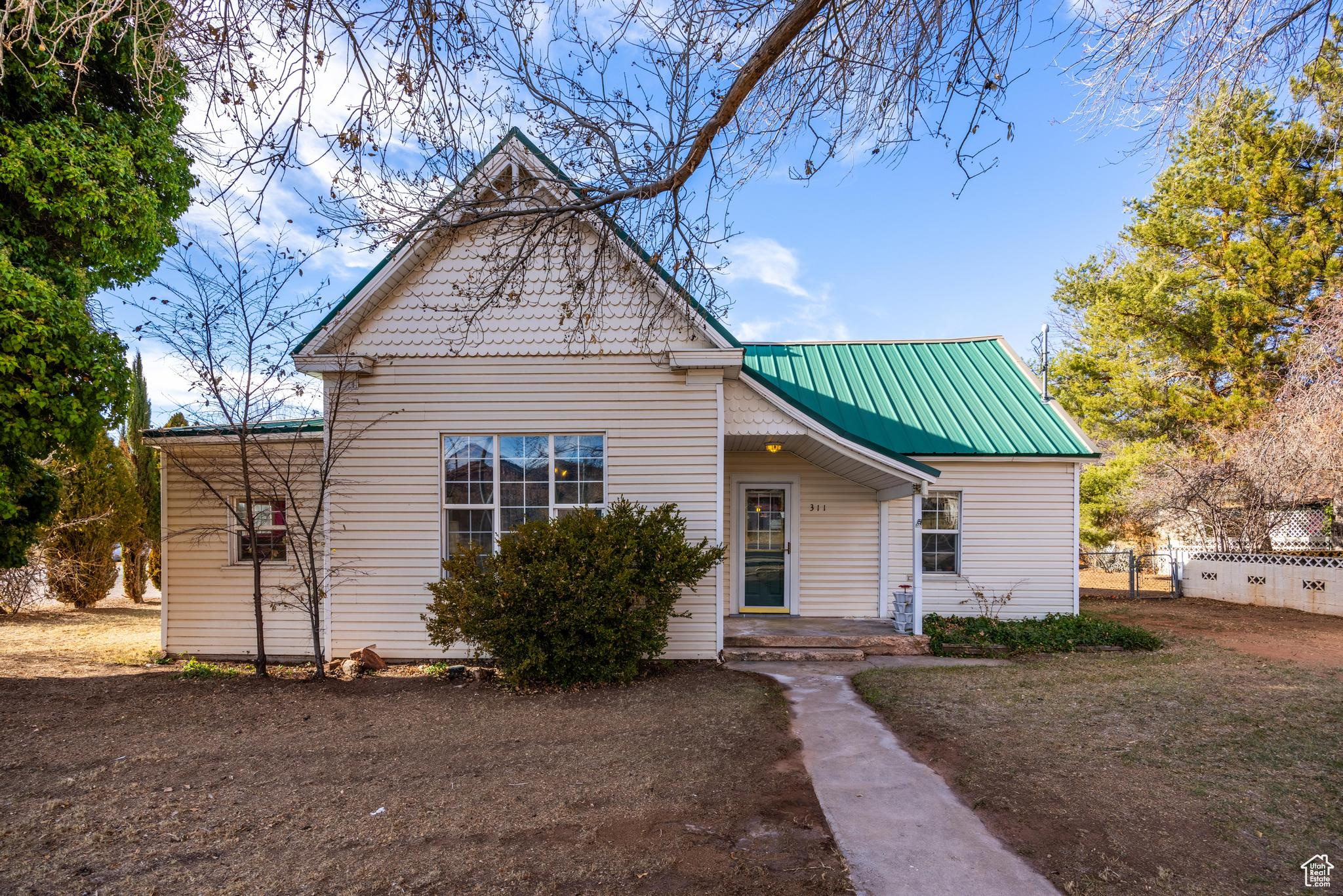 View of front facade with metal roof and fence