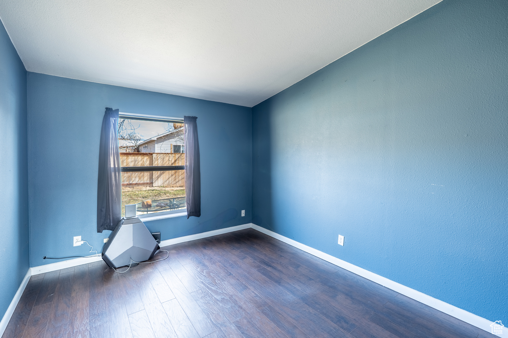 Unfurnished room featuring baseboards and wood finished floors