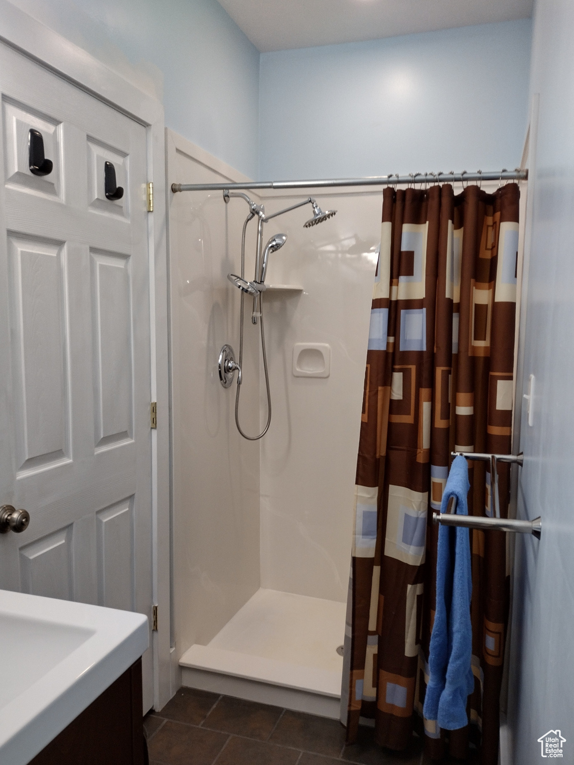 Bathroom with tile patterned floors, a stall shower, and vanity