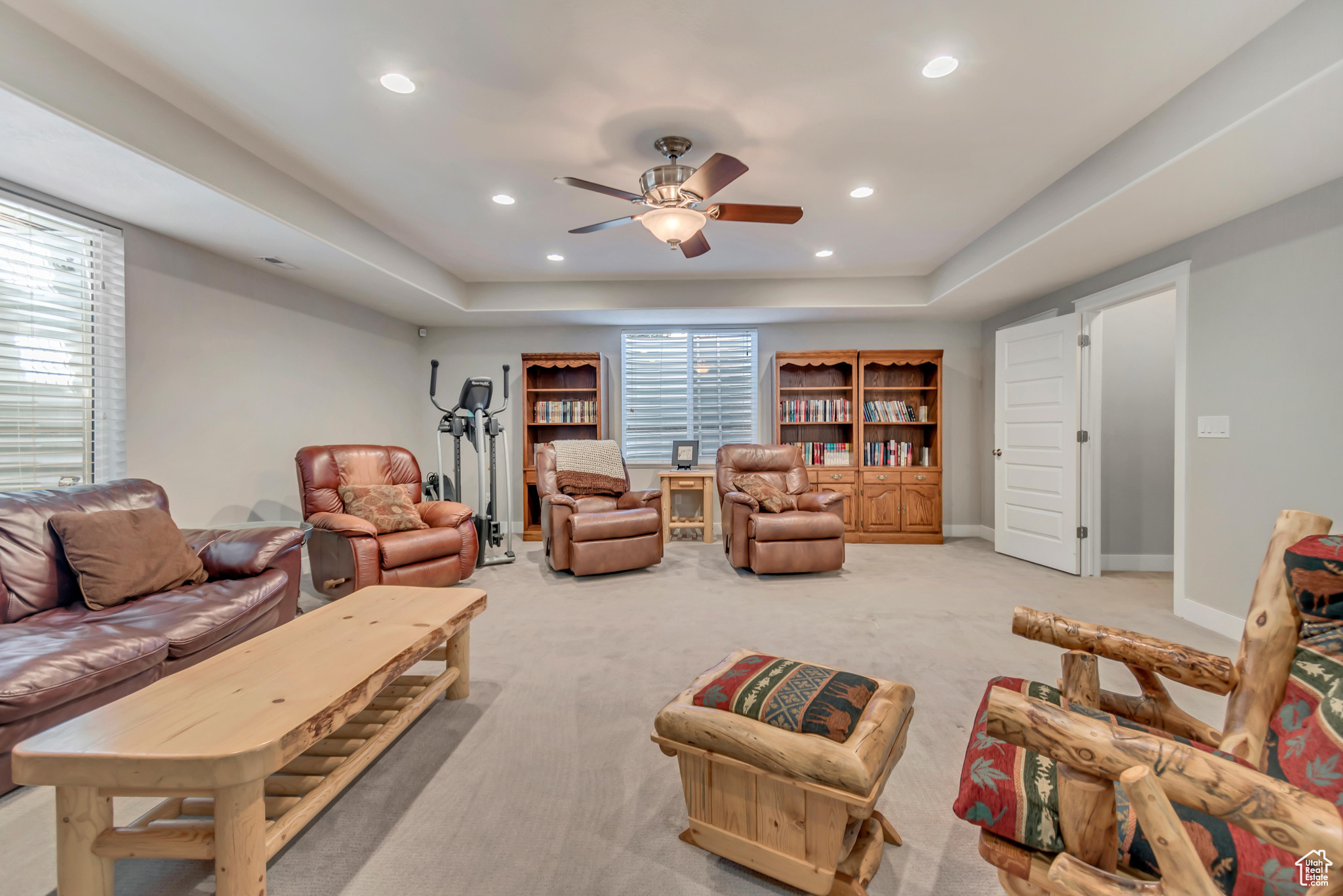 Living area with a tray ceiling, a ceiling fan, recessed lighting, carpet