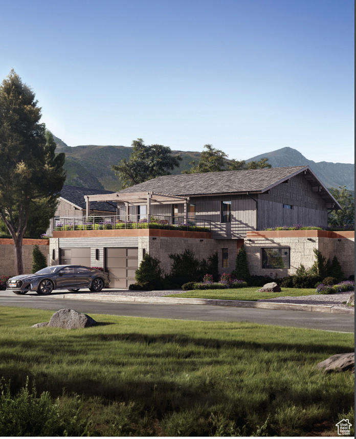 View of front facade with a mountain view, a garage, and a front yard