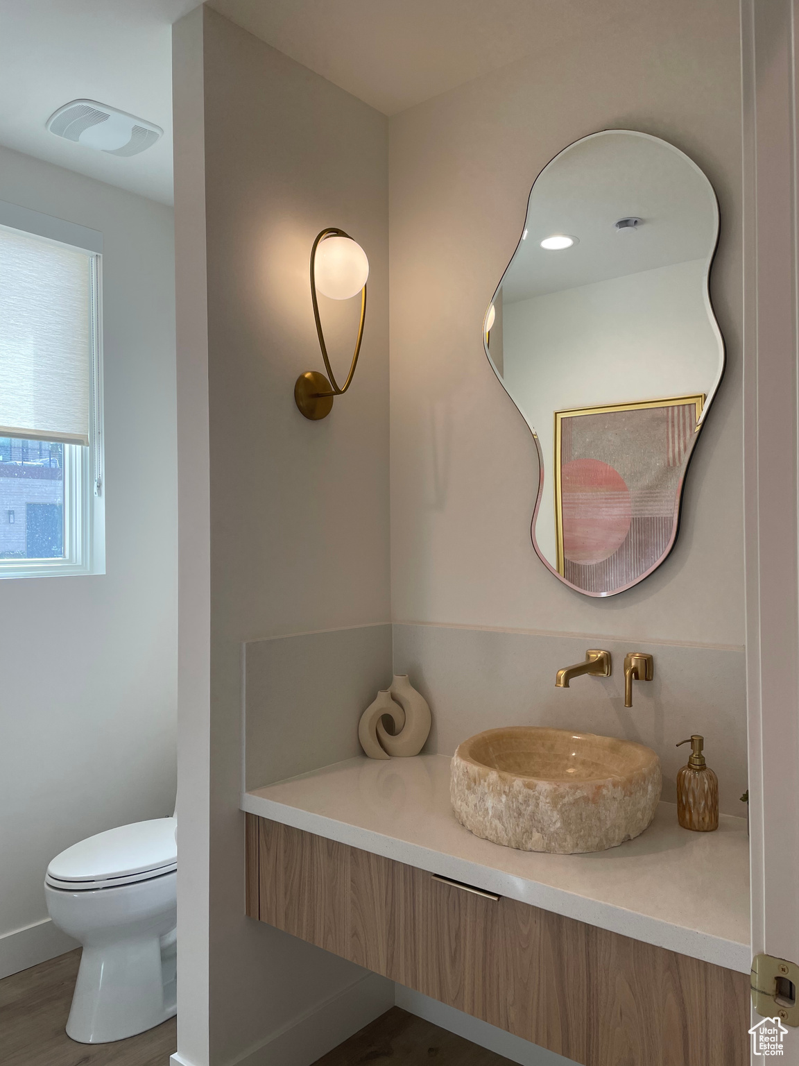 Bathroom with vanity, toilet, wood finished floors, and visible vents