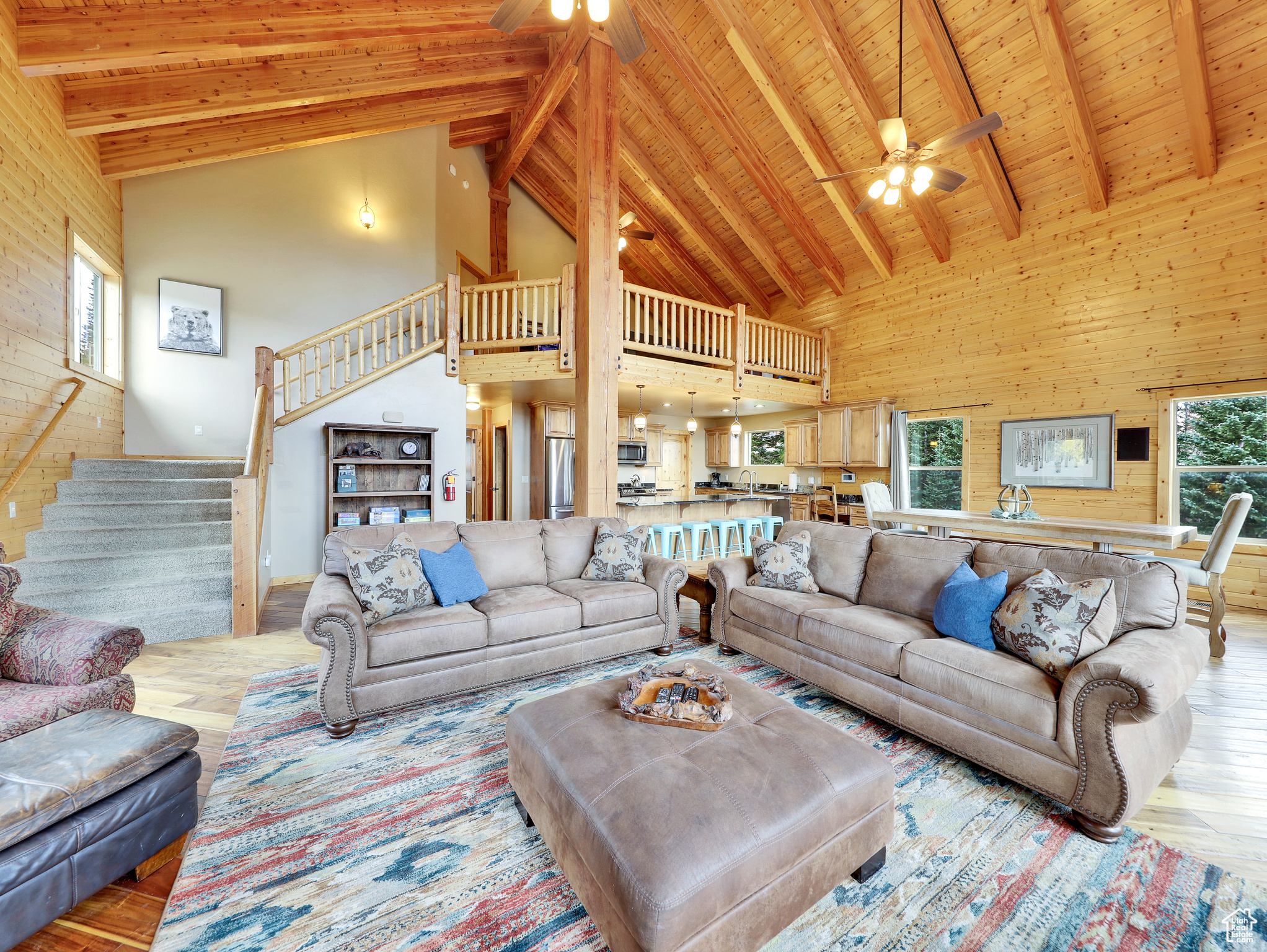 Living area with stairway, wood finished floors, a ceiling fan, beam ceiling, and wood ceiling