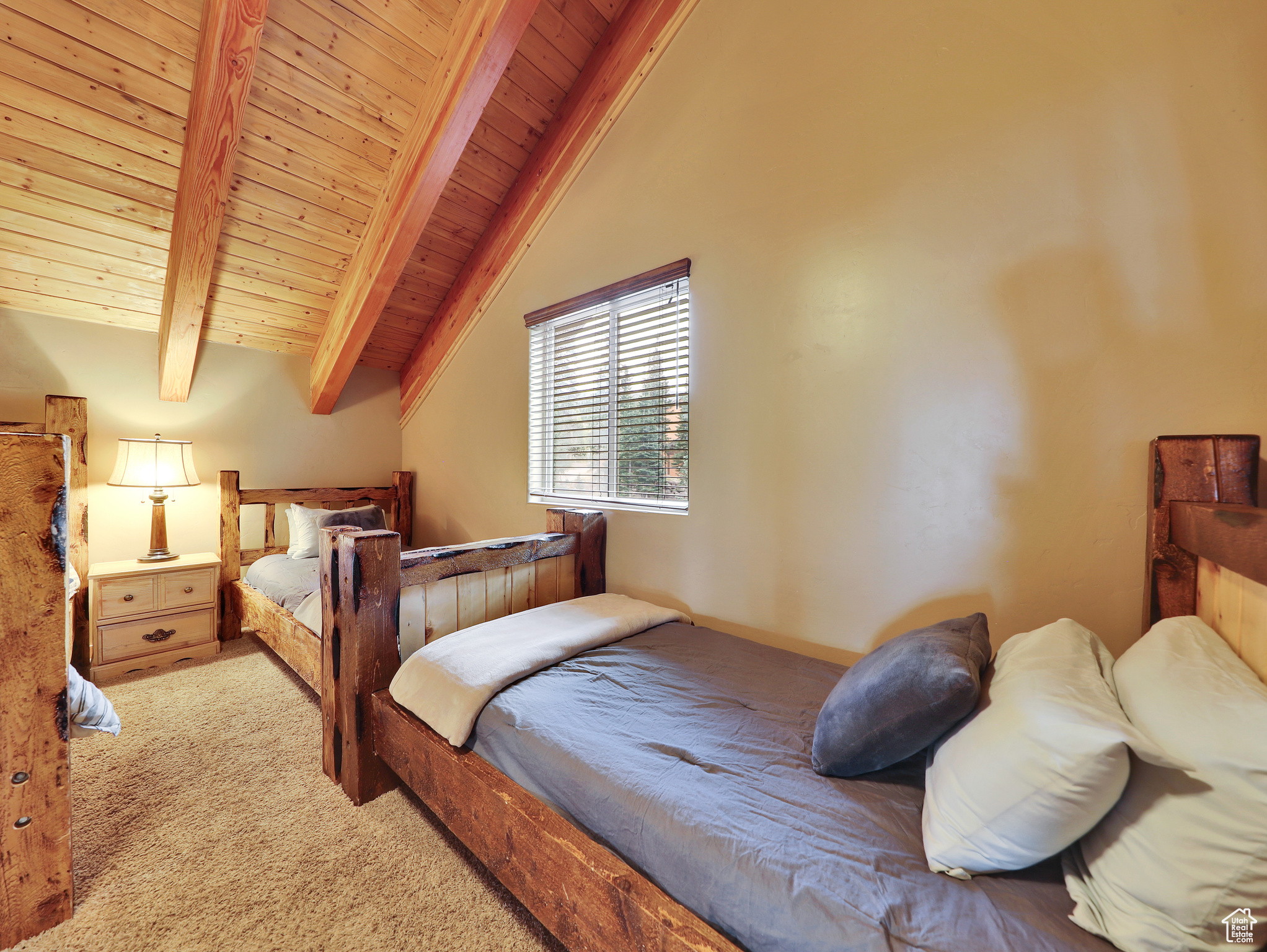 Bedroom featuring wooden ceiling, carpet flooring, and vaulted ceiling with beams