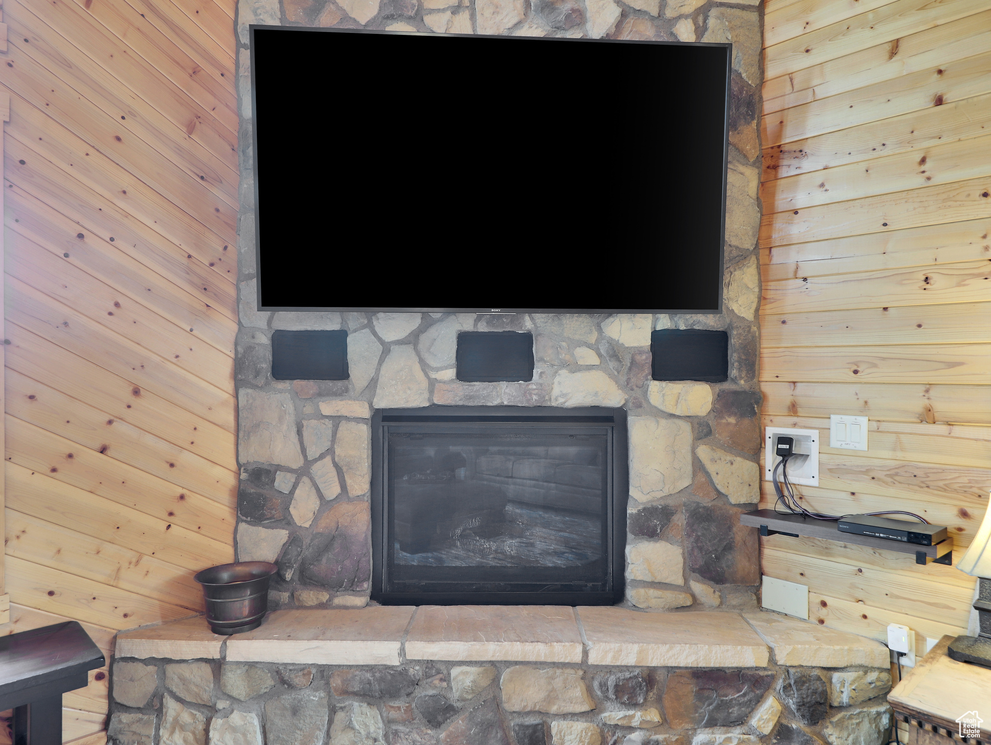 Room details featuring wooden walls and a fireplace