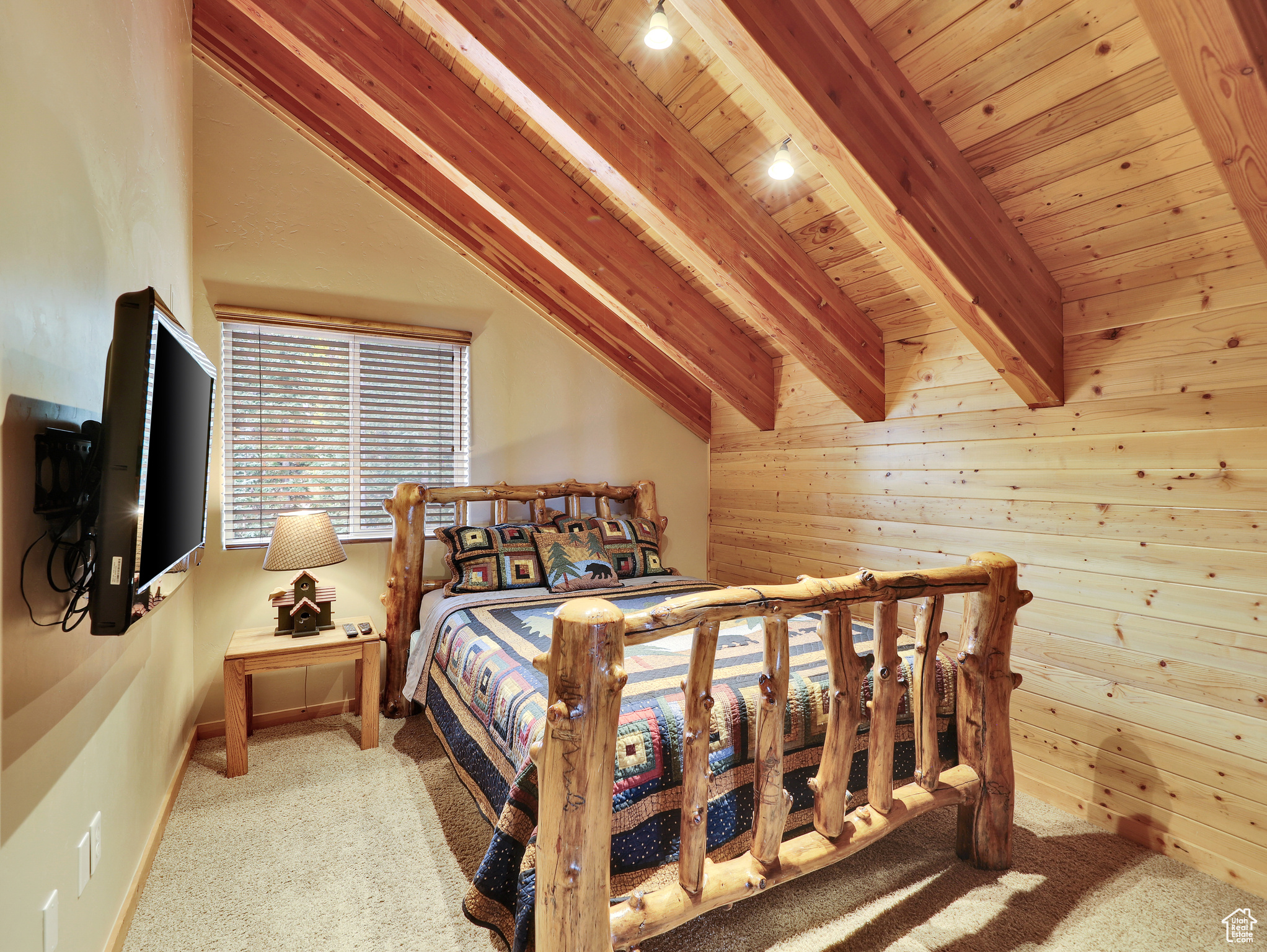 Carpeted bedroom featuring wooden walls, wooden ceiling, lofted ceiling with beams, and baseboards