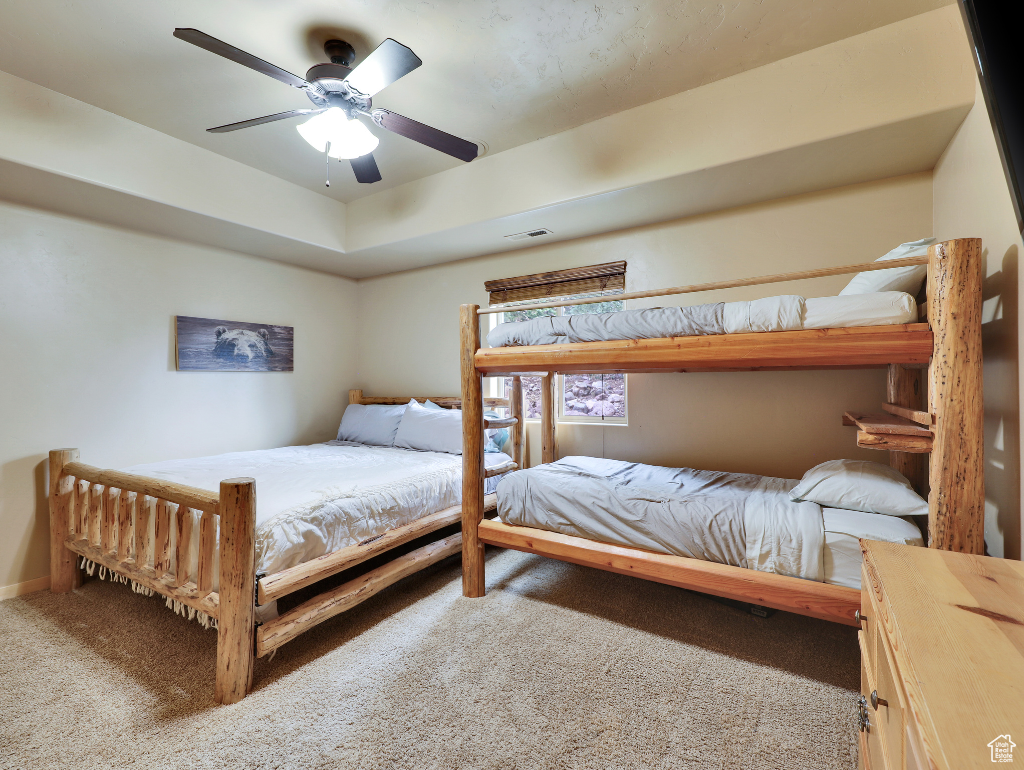 Bedroom with visible vents, ceiling fan, baseboards, carpet, and a tray ceiling