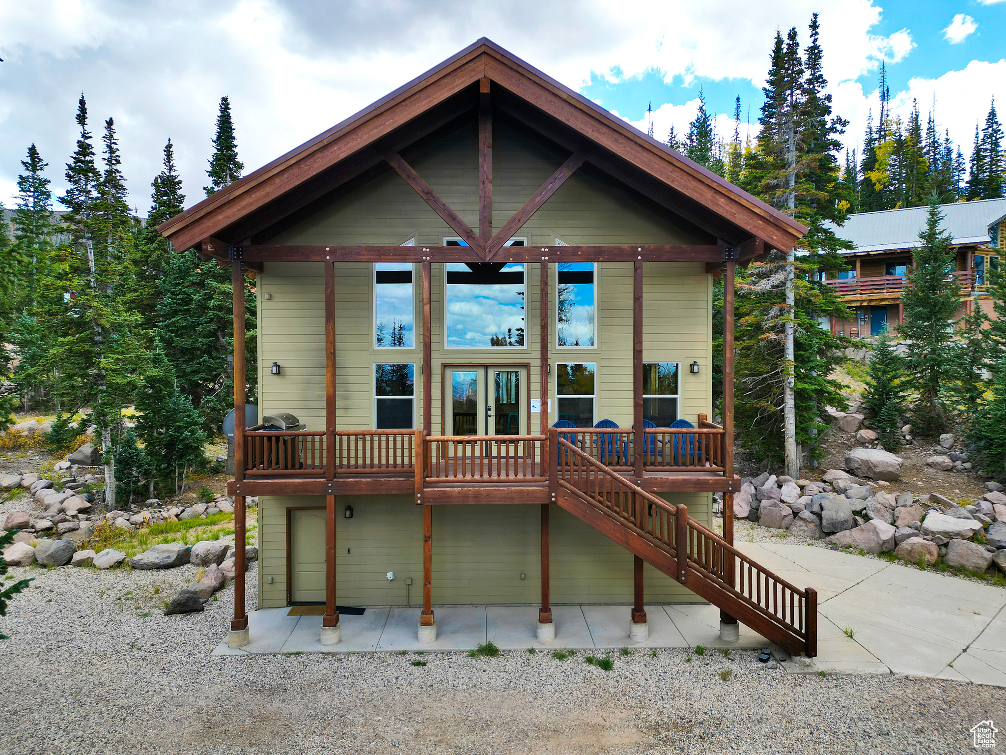 Back of house with french doors, a wooden deck, and stairs
