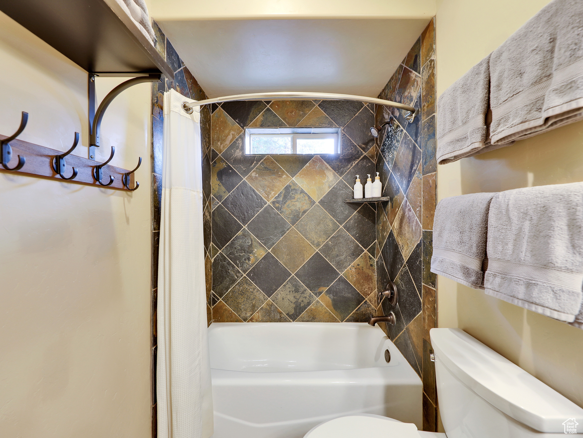 Full bath with toilet and shower / bathtub combination with curtain