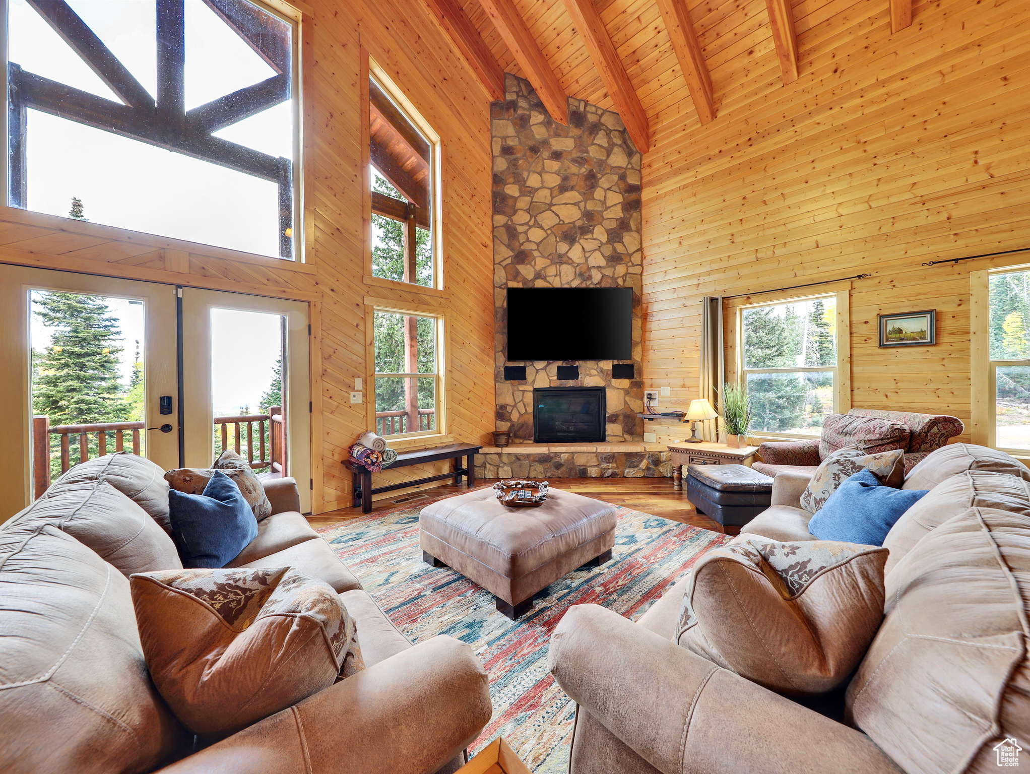 Living area featuring lofted ceiling with beams, wood finished floors, wood walls, a fireplace, and wood ceiling