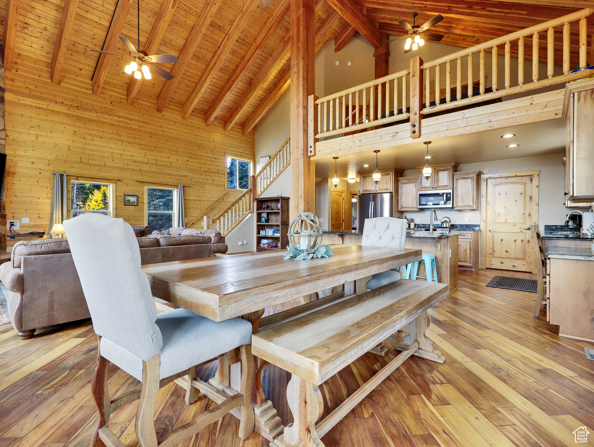 Dining area featuring light wood finished floors, wooden walls, wooden ceiling, and beam ceiling