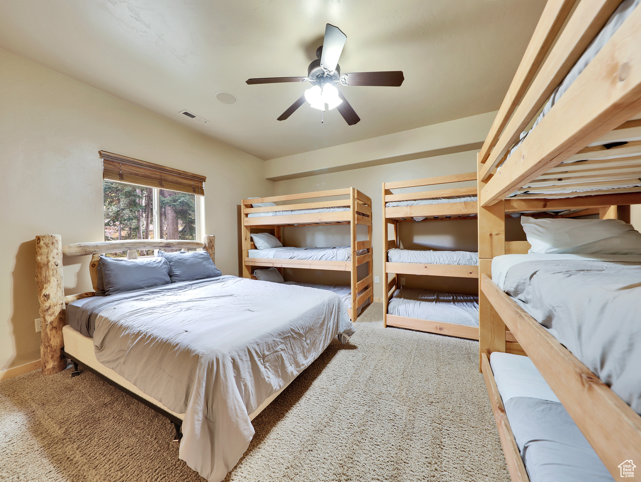 Carpeted bedroom with visible vents, baseboards, and ceiling fan