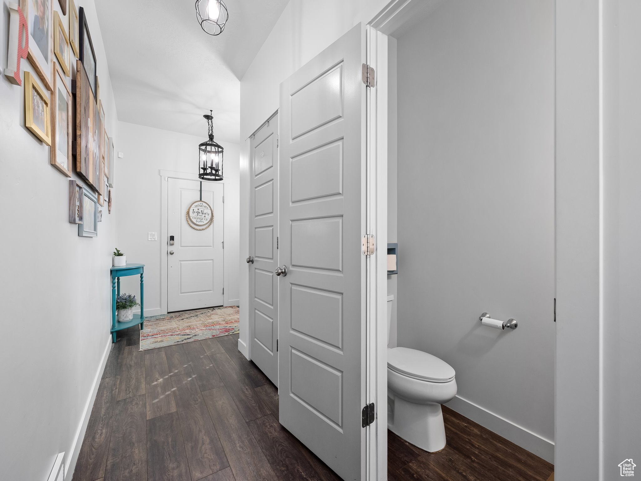 Bathroom with toilet, wood finished floors, and baseboards