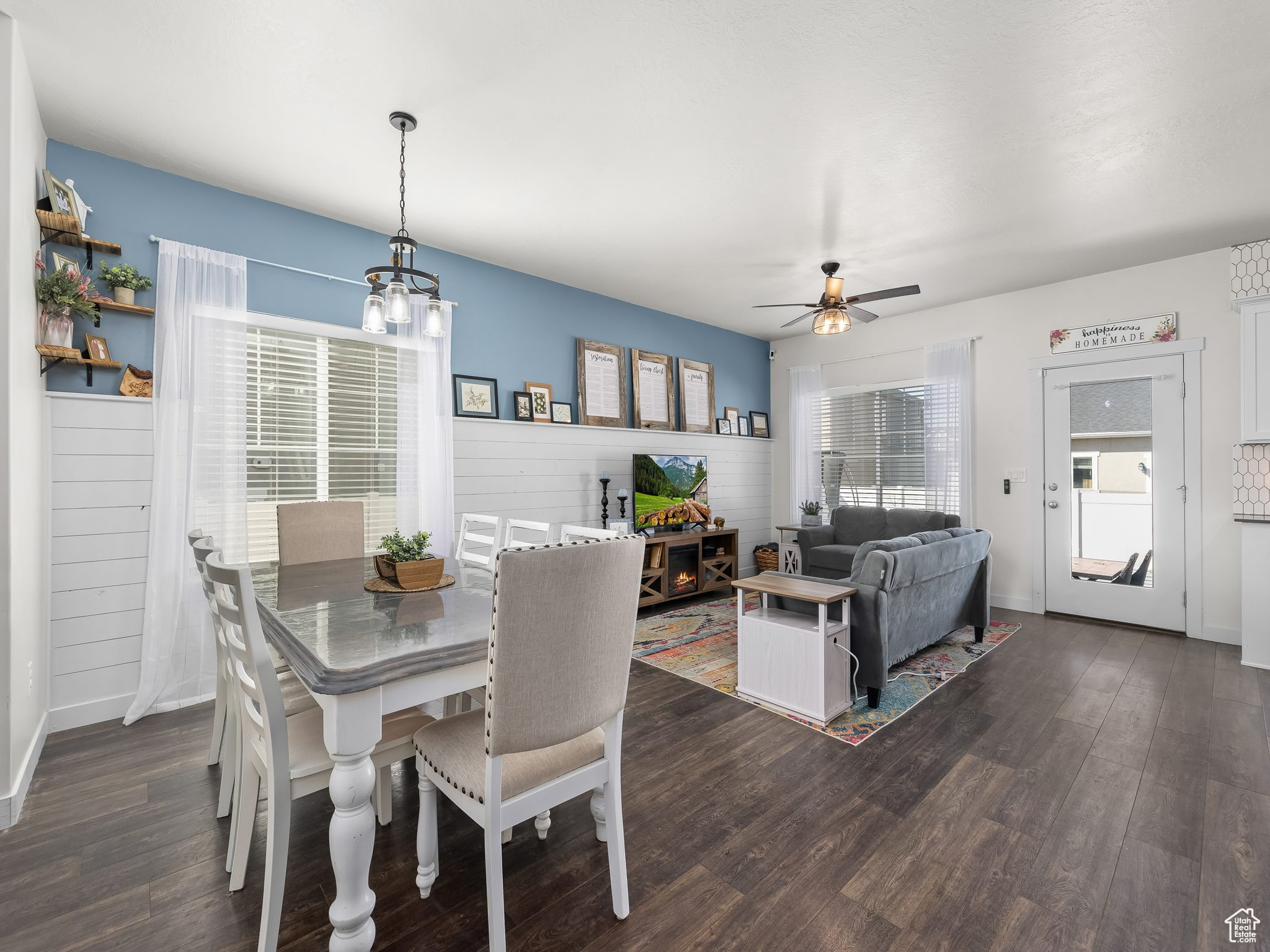 Dining area featuring dark wood finished floors and ceiling fan with notable chandelier