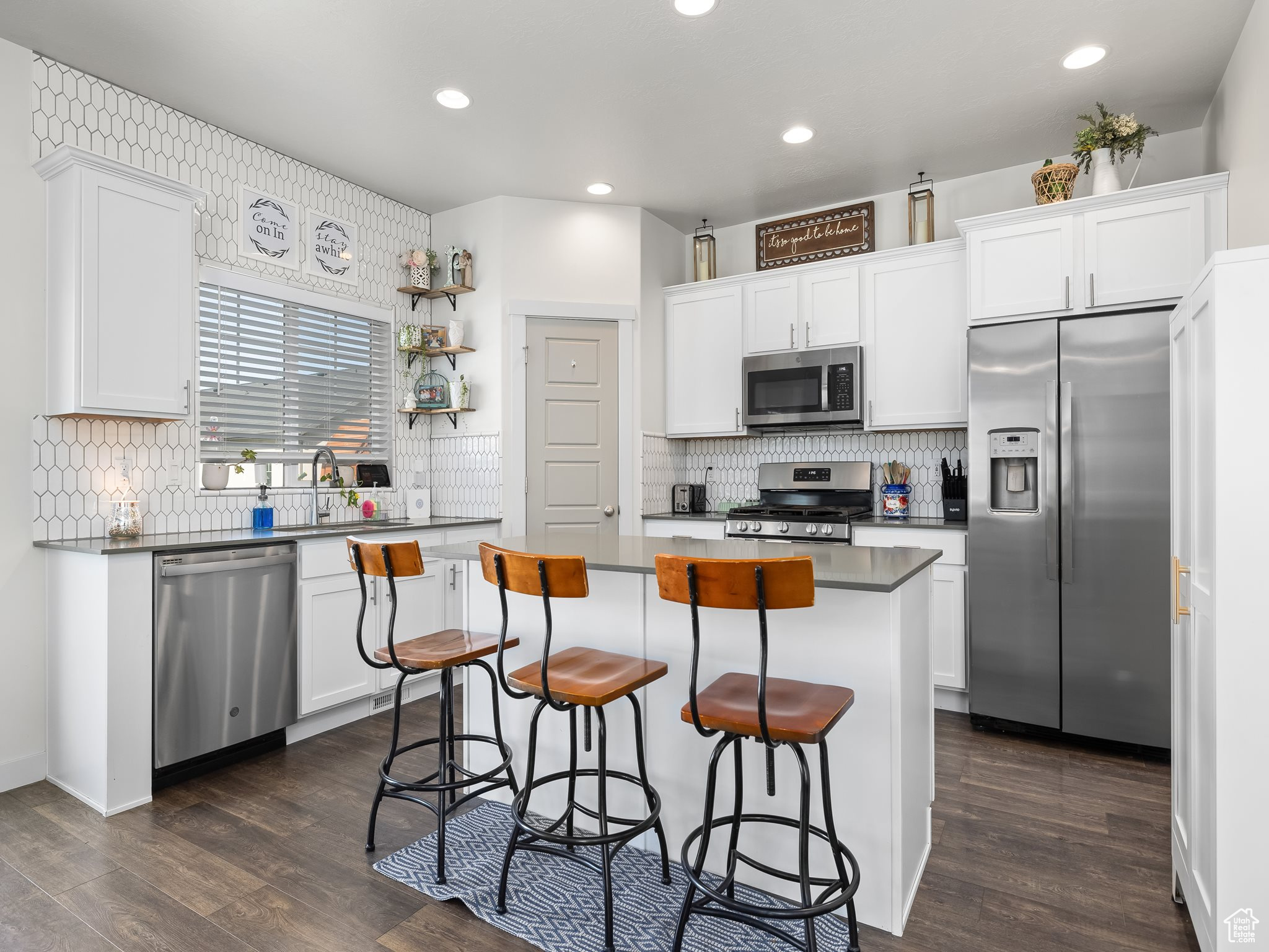 Kitchen featuring white cabinets, appliances with stainless steel finishes, and a kitchen island