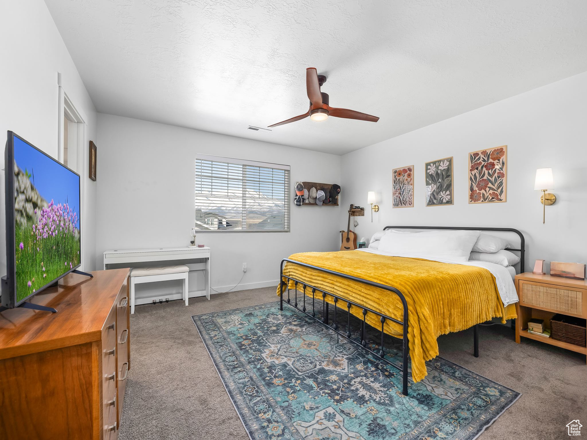 Carpeted bedroom with a textured ceiling, a ceiling fan, visible vents, and baseboards