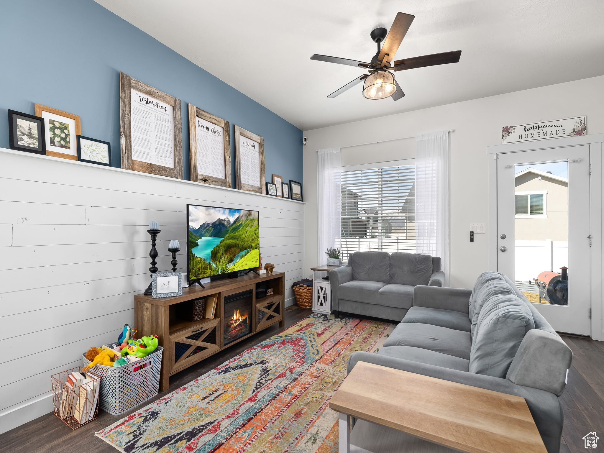 Living room with ceiling fan, a healthy amount of sunlight, and wood finished floors