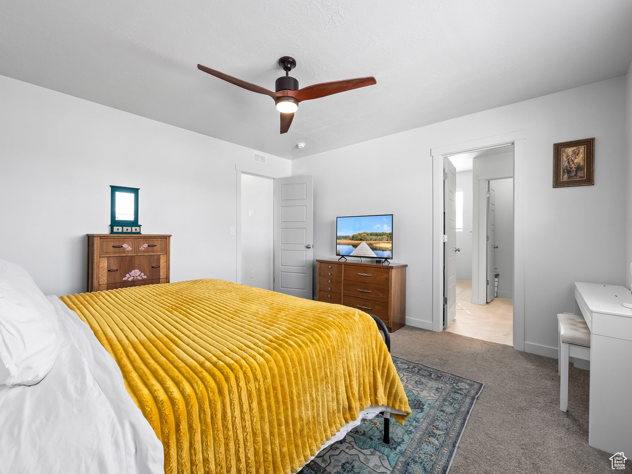 Carpeted bedroom featuring visible vents, multiple windows, a ceiling fan, and baseboards