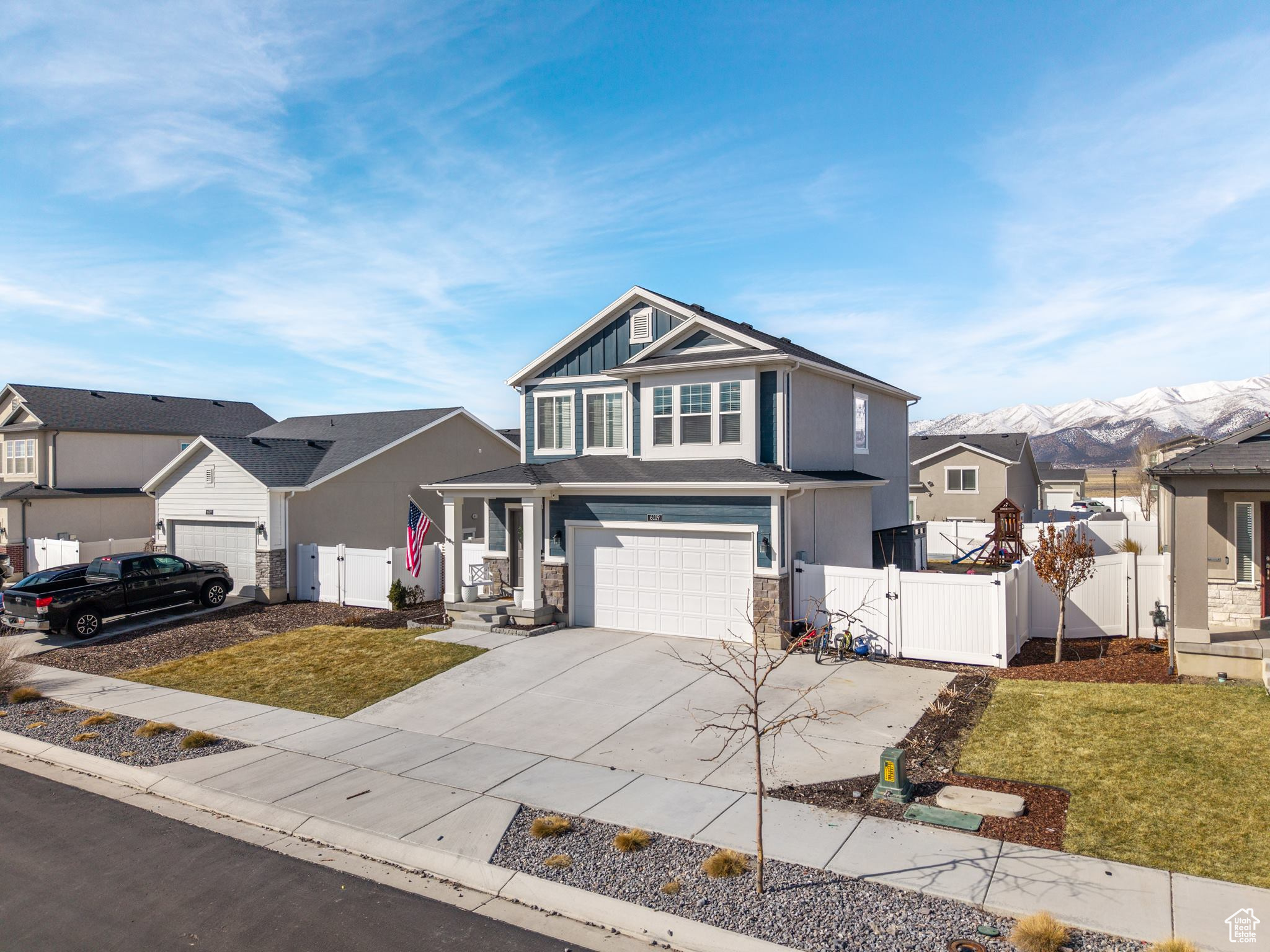 View of front of property with a residential view, fence, driveway, and a gate