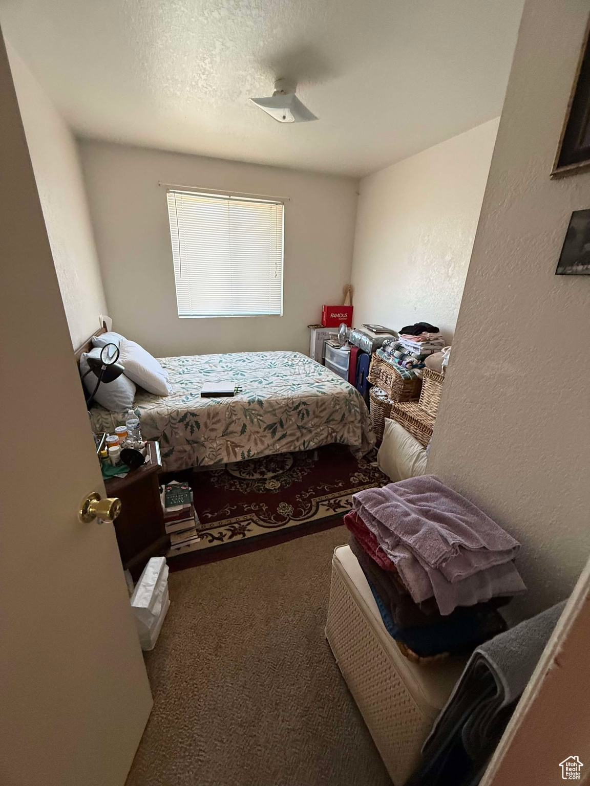 Bedroom with a textured ceiling, a textured wall, and carpet floors