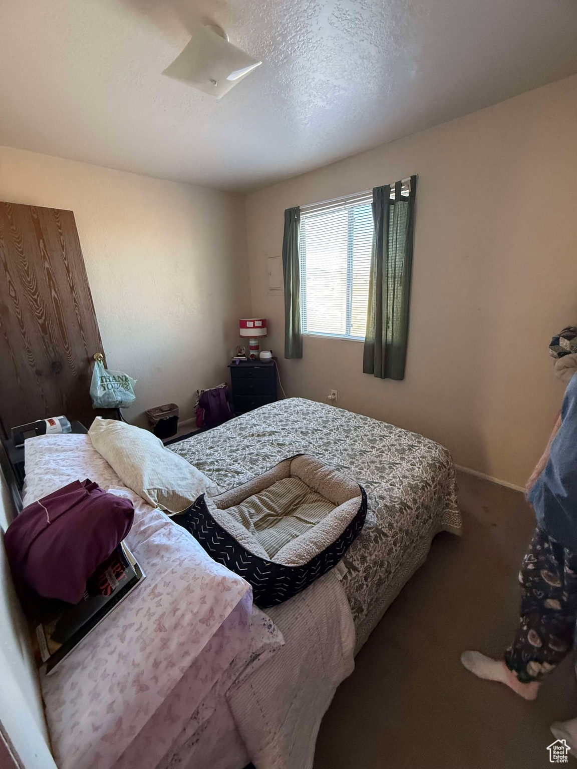 Bedroom with a textured ceiling, baseboards, and carpet floors