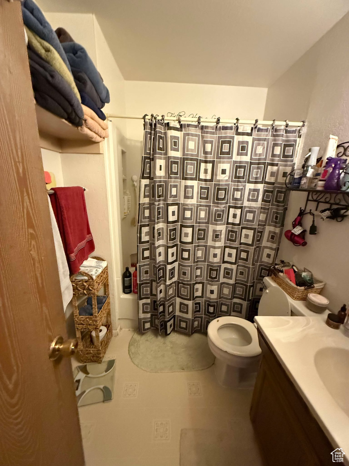 Full bathroom featuring toilet, vanity, and a shower with curtain