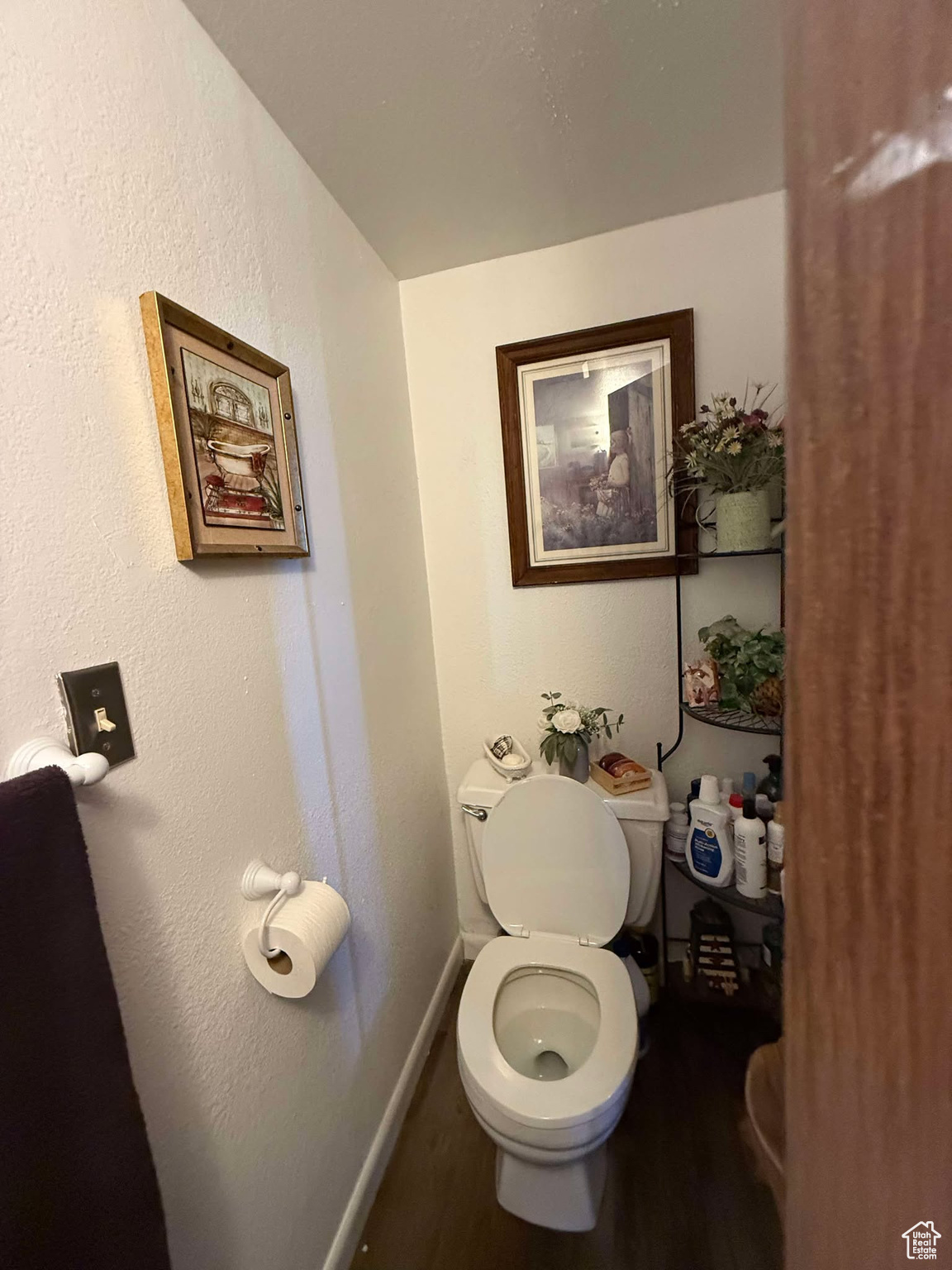 Bathroom with toilet, baseboards, and wood finished floors