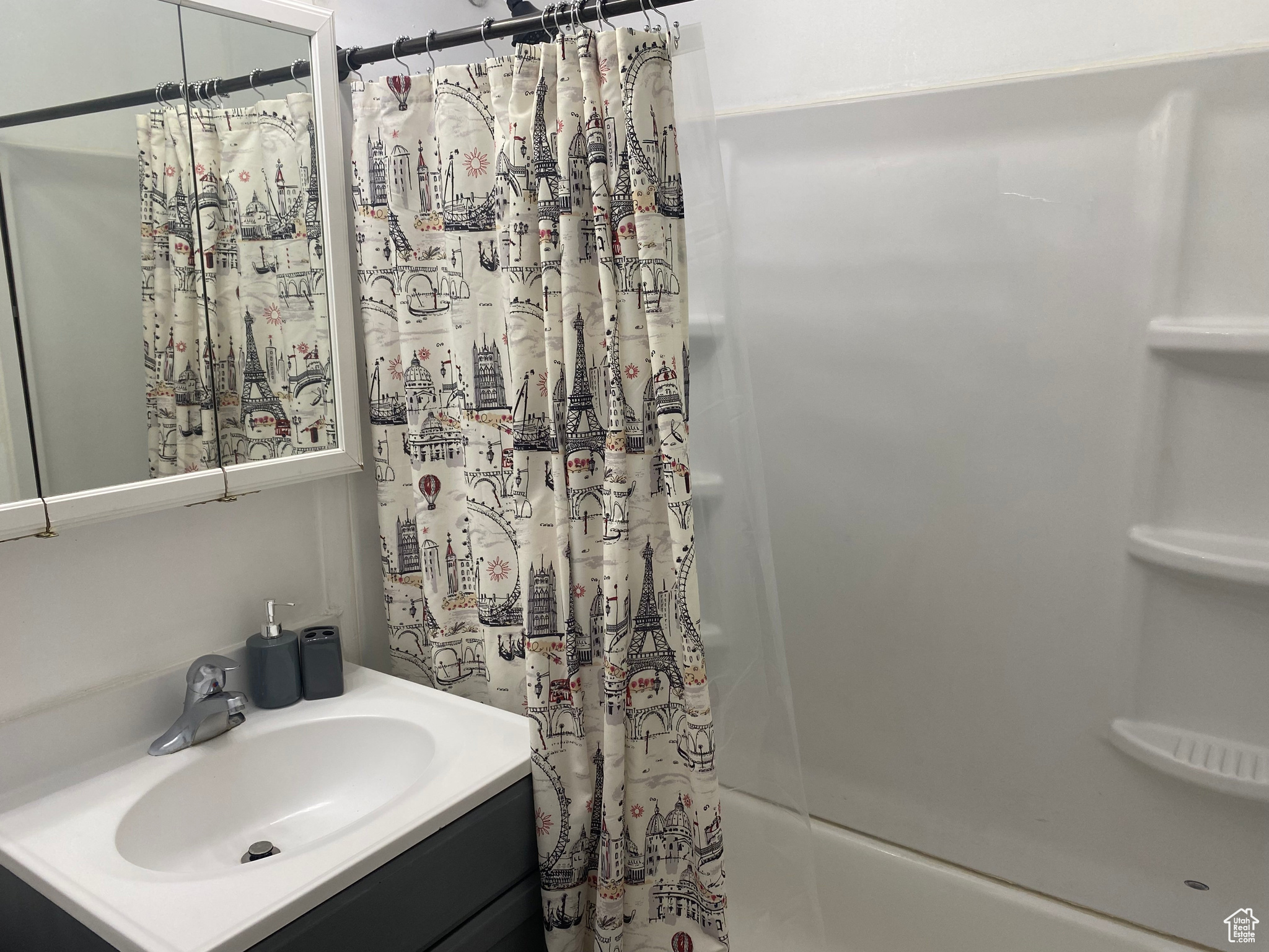 Bathroom featuring vanity and shower / bath combination with curtain