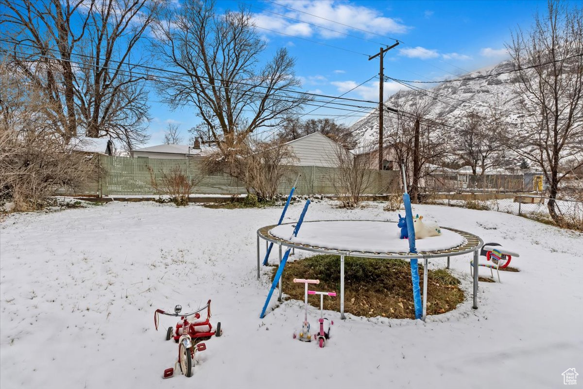 Exterior space featuring a trampoline and a fenced backyard