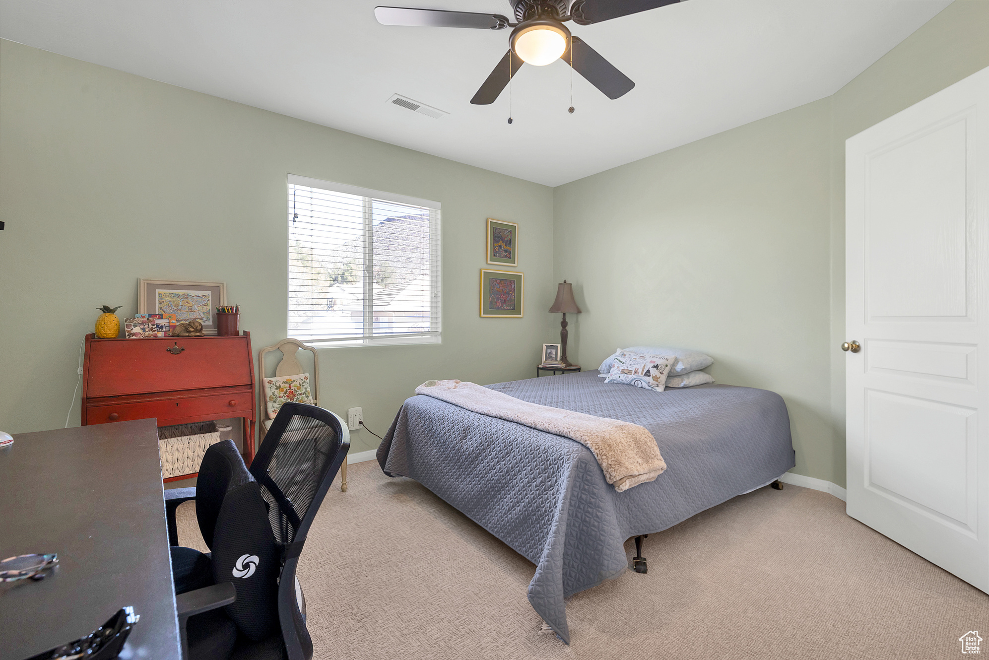 Bedroom with light carpet, visible vents, baseboards, and a ceiling fan