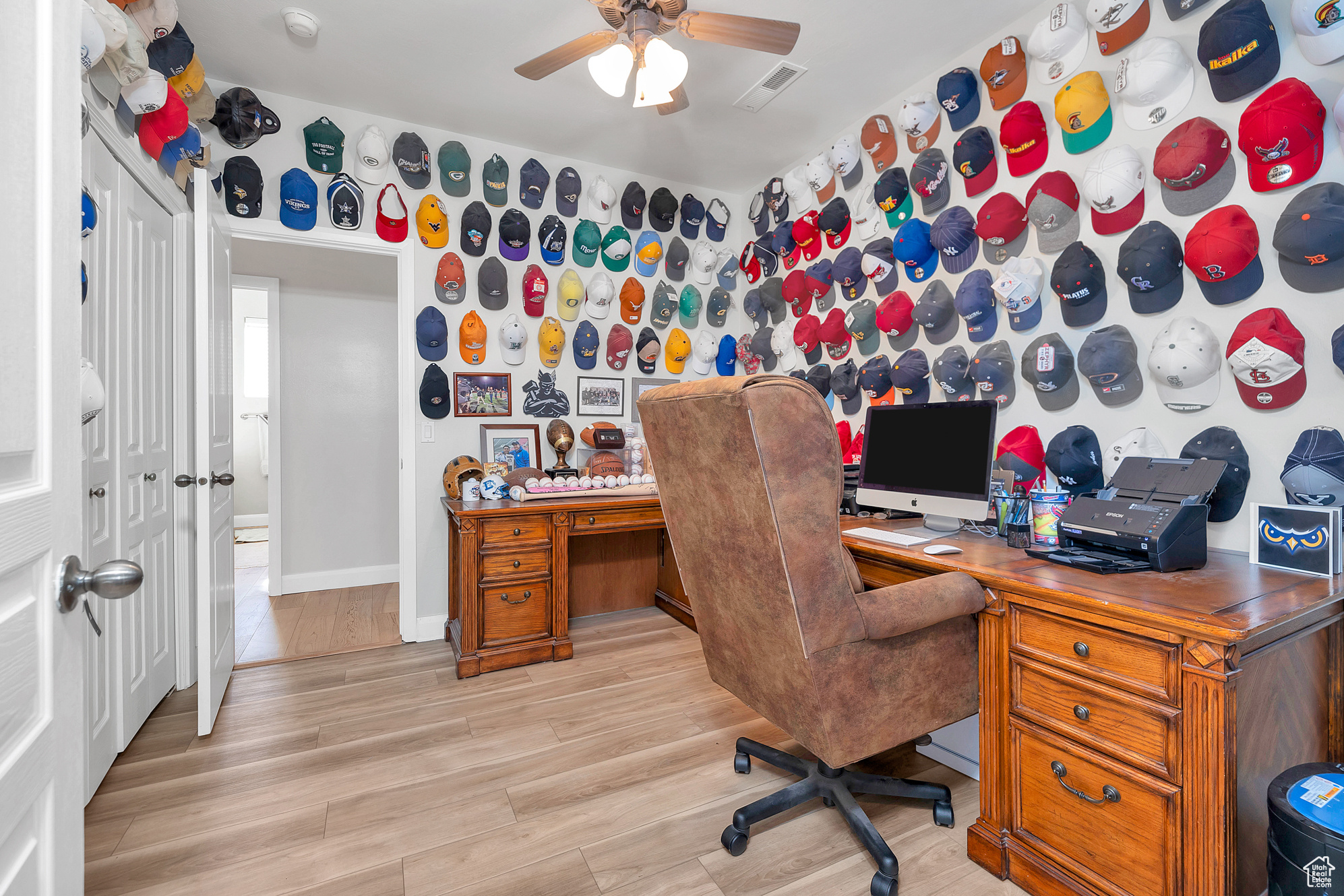 Office area featuring visible vents, baseboards, light wood-type flooring, and ceiling fan