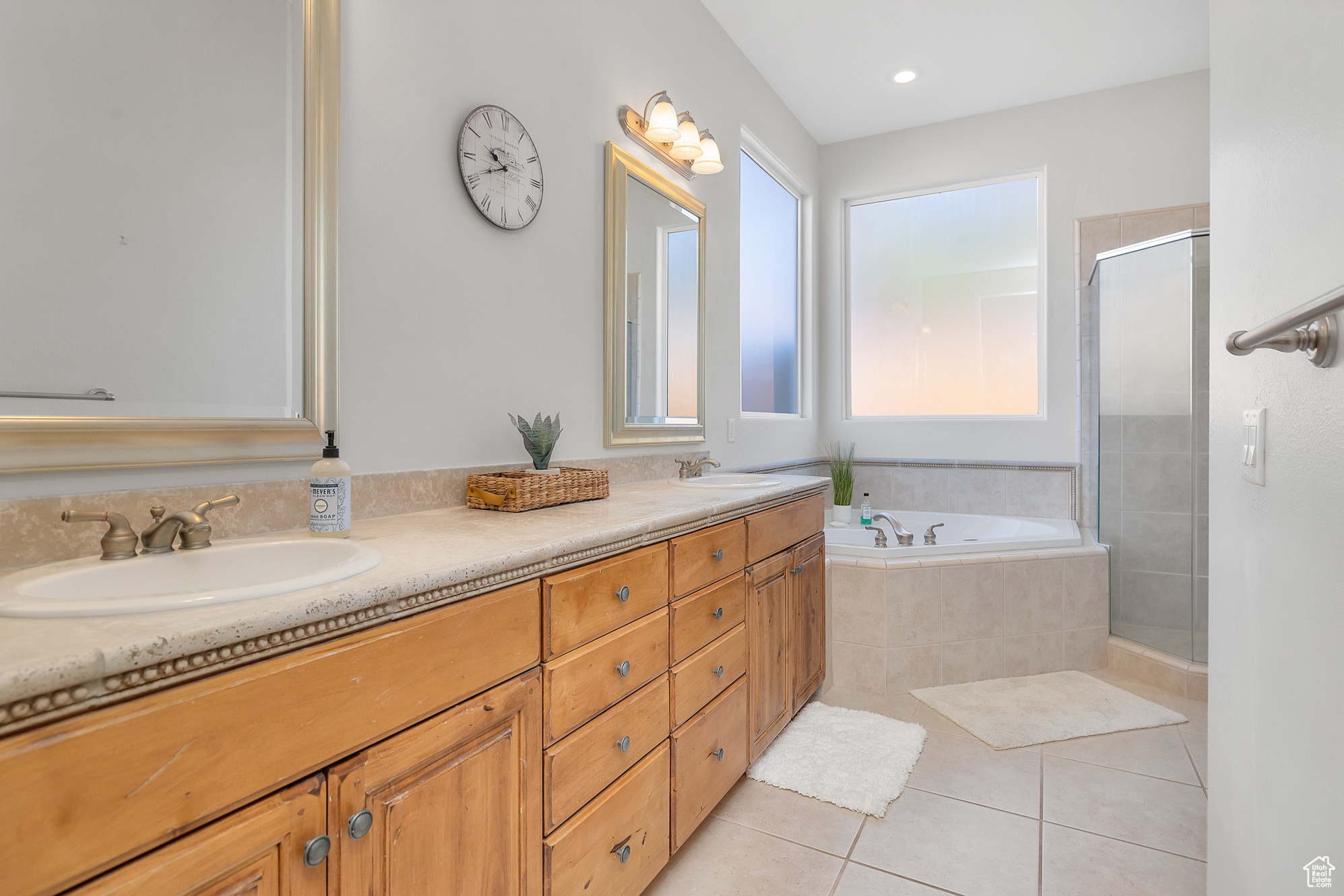 Full bath with tile patterned flooring, a shower stall, a garden tub, double vanity, and a sink